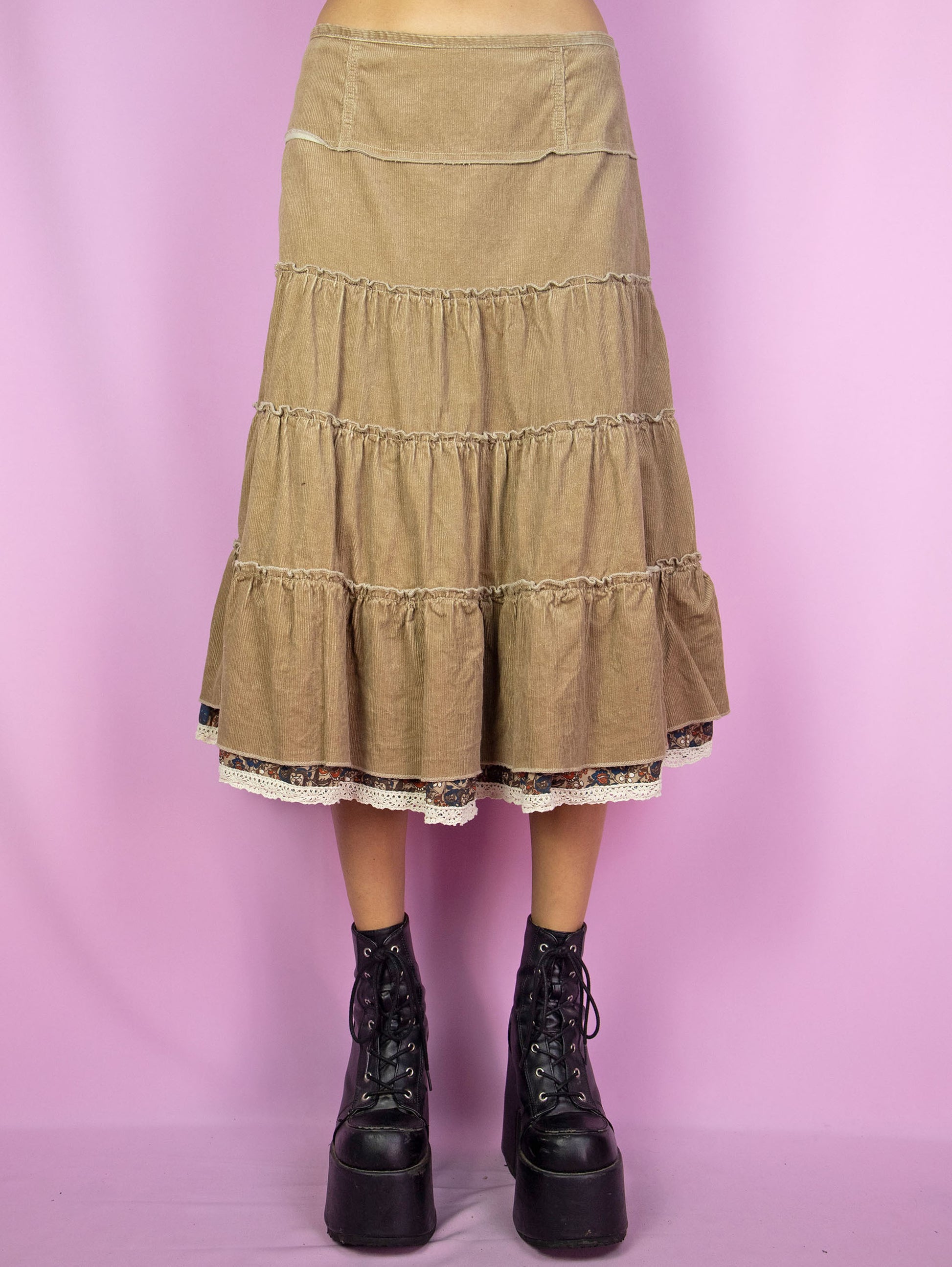 The Y2K Brown Corduroy Tiered Skirt is a vintage 2000s cottage prairie inspired&nbsp; light brown beige peasant midi skirt with a side zipper closure.