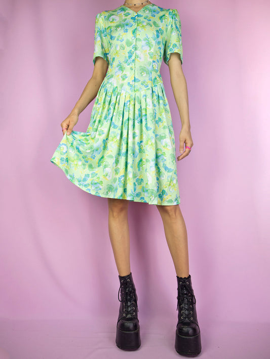 The Vintage 90s Floral Print Midi Dress is a boho summer style light green, blue and yellow abstract flower graphic short sleeve button pleated dress.