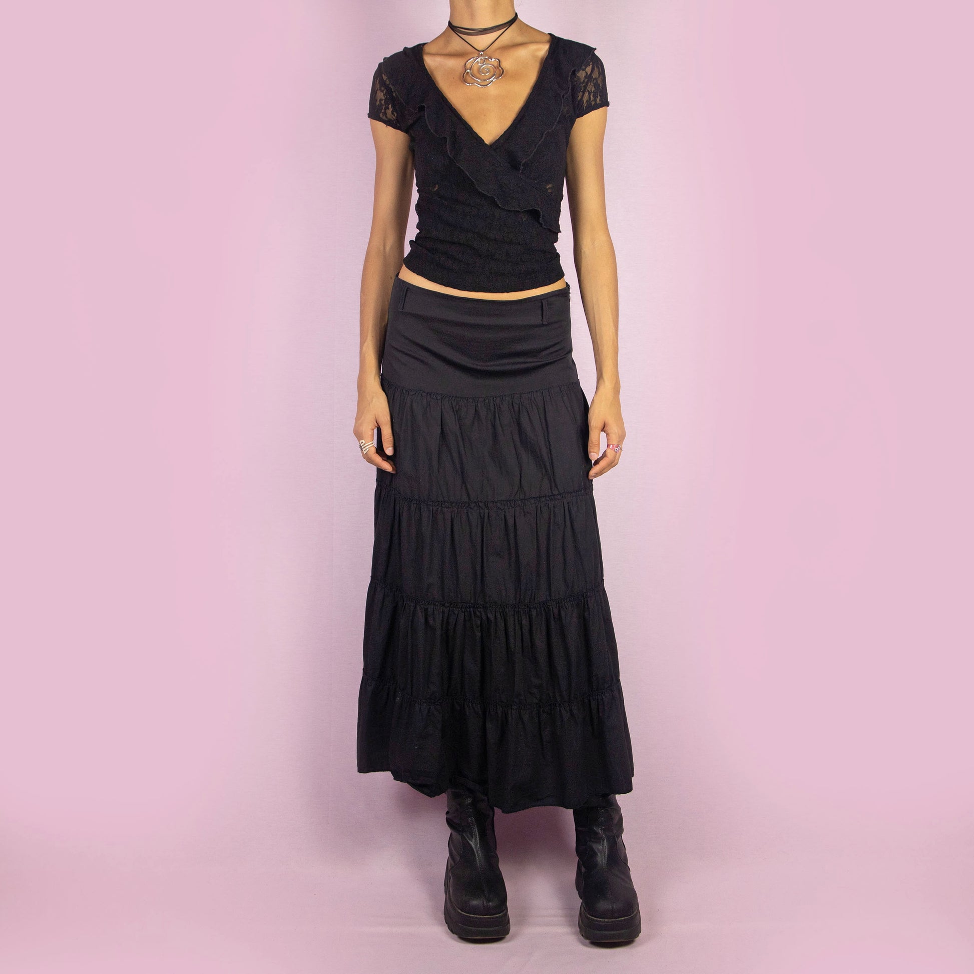 The Y2K Black Tiered Midi Skirt is a vintage 2000s piece featuring a side zipper closure and multiple gathered tiers, creating a flowy and voluminous silhouette. Perfect for summer nights.