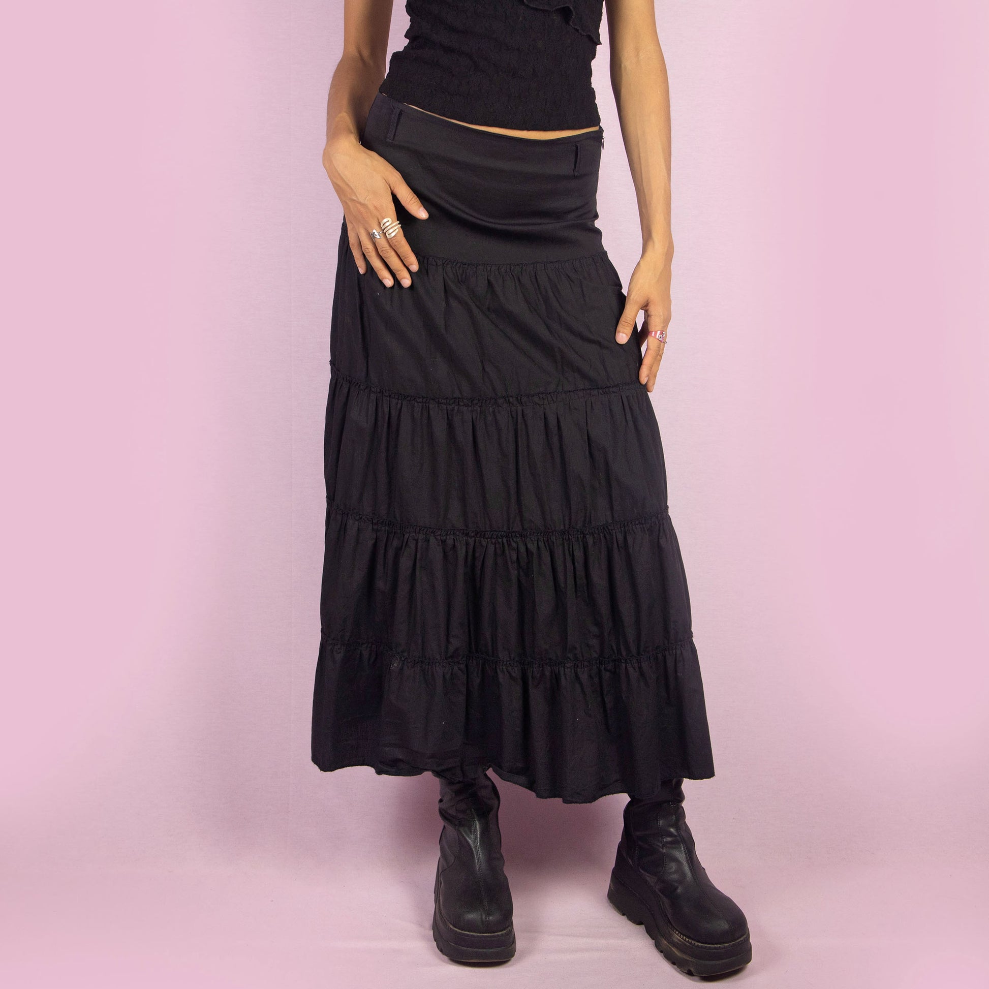 The Y2K Black Tiered Midi Skirt is a vintage 2000s piece featuring a side zipper closure and multiple gathered tiers, creating a flowy and voluminous silhouette. Perfect for summer nights.