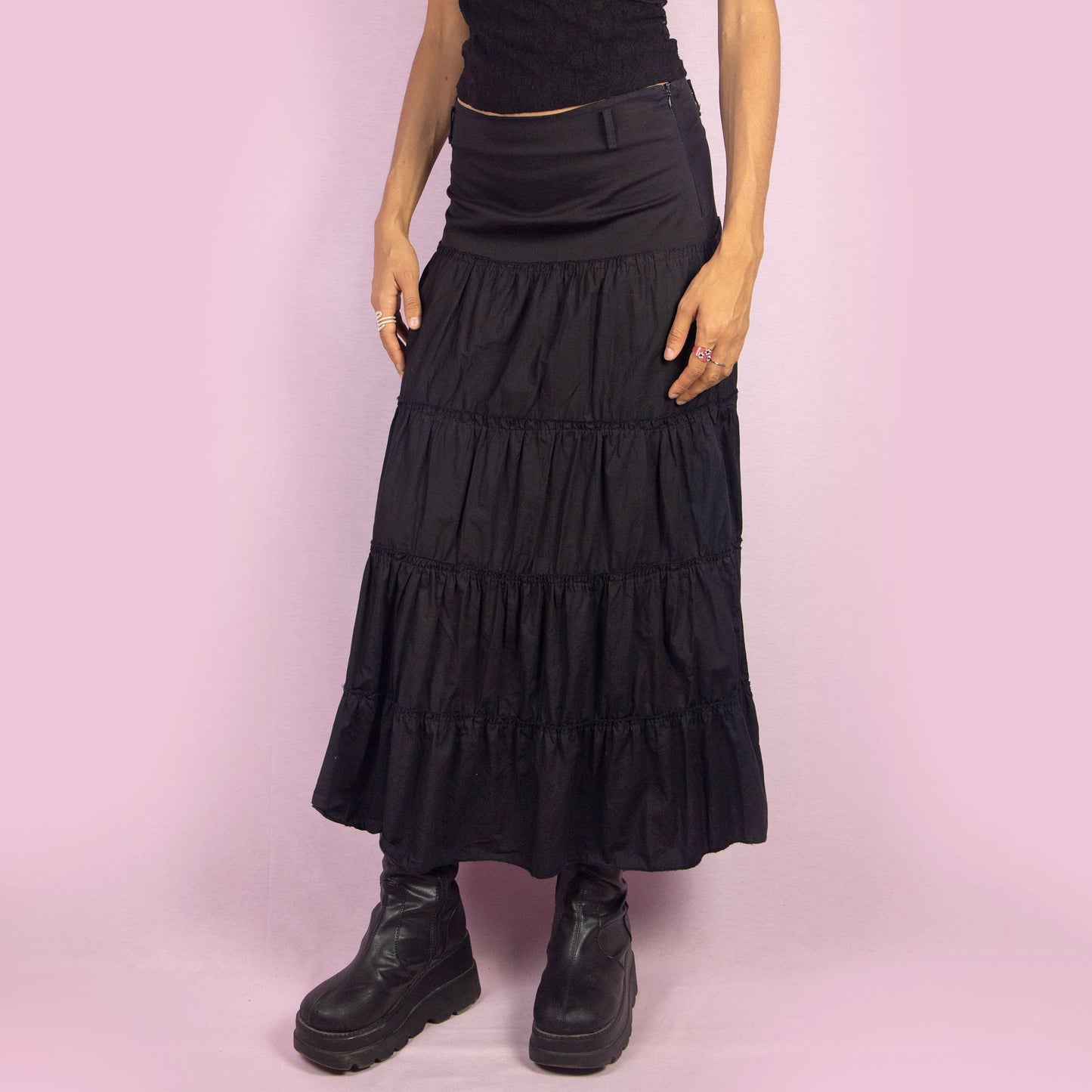 The Y2K Black Tiered Midi Skirt is a vintage 2000s piece featuring a side zipper closure and multiple gathered tiers, creating a flowy and voluminous silhouette. Perfect for summer nights.