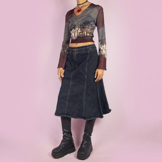 The Y2K Denim Belted Trumpet Skirt is a vintage 2000s piece featuring a high-waist design with a unique belt detail and a front zipper closure. The skirt is panelled and flares out into a subtle trumpet silhouette, crafted from a stretchy, dark denim fabric. Ideal for casual outfits.