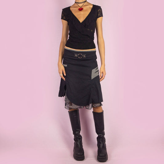 The Y2K Layered Asymmetric Black Skirt is a vintage 2000s piece featuring a high-waist design with an asymmetric hemline and a unique layered look. It includes a subtle floral print underlayer, a decorative belt detail on the waist, and contrasting fabric patches. With stretchy fabric and a back zipper closure, this skirt is perfect for casual summer outfits.