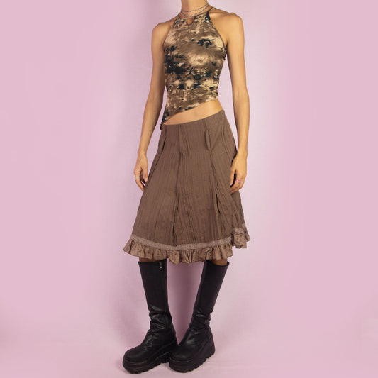 The Y2K Brown Flared Skirt is a vintage 2000s high-waisted skirt featuring a side zipper closure, a crinkled fabric texture, and delicate lace trim along the hemline with ruffle detailing. Perfect for casual or summer looks.