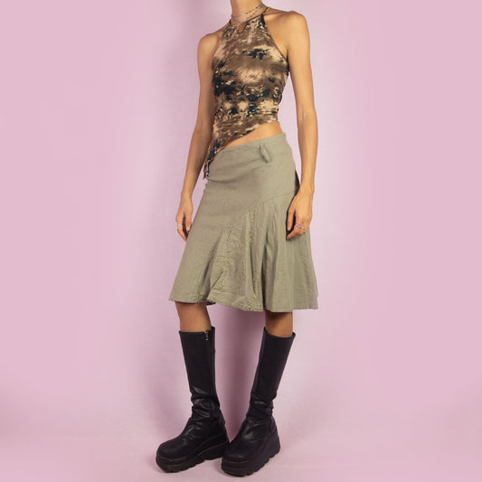 The Y2K Khaki Flared Trumpet Skirt is a vintage 2000s midi skirt crafted from a lightweight linen-cotton blend. It features a high-waisted fit with a side zipper closure, complemented by a flared trumpet silhouette with subtle embroidery details. Perfect for casual, boho-inspired summer and spring outfits.