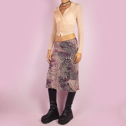 The Y2K Abstract Print Midi Skirt is a vintage 2000s piece featuring a vibrant abstract print in shades of purple and an elastic waistband. Perfect for casual outings or a summer night look.