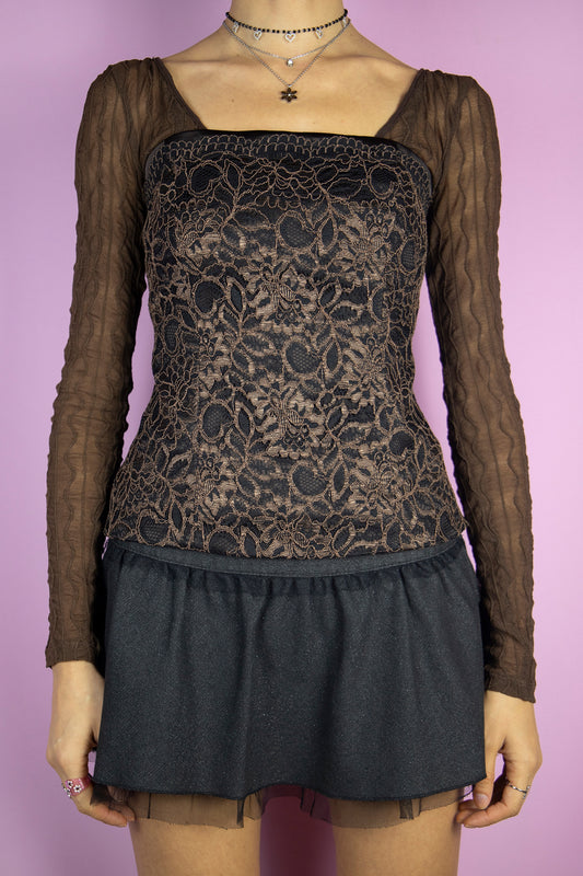 The Y2K Brown Lace Corset Top is a vintage brown and black strapless lace top with boning, buttons at the back, side zipper closure, and a ribbon that ties like a bow. Elegant fairy goth 2000s party night bustier. </span>The brown long-sleeved top shown underneath is not included.