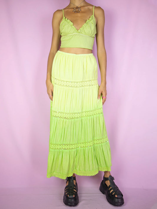 The Y2K Green Tiered Maxi Skirt is a vintage 2000s neon lime green gradient peasant midi skirt featuring an elastic waist and sequin details. Embracing a boho style, it's perfect for summer beach outings or adding a vibrant touch to any party outfit.