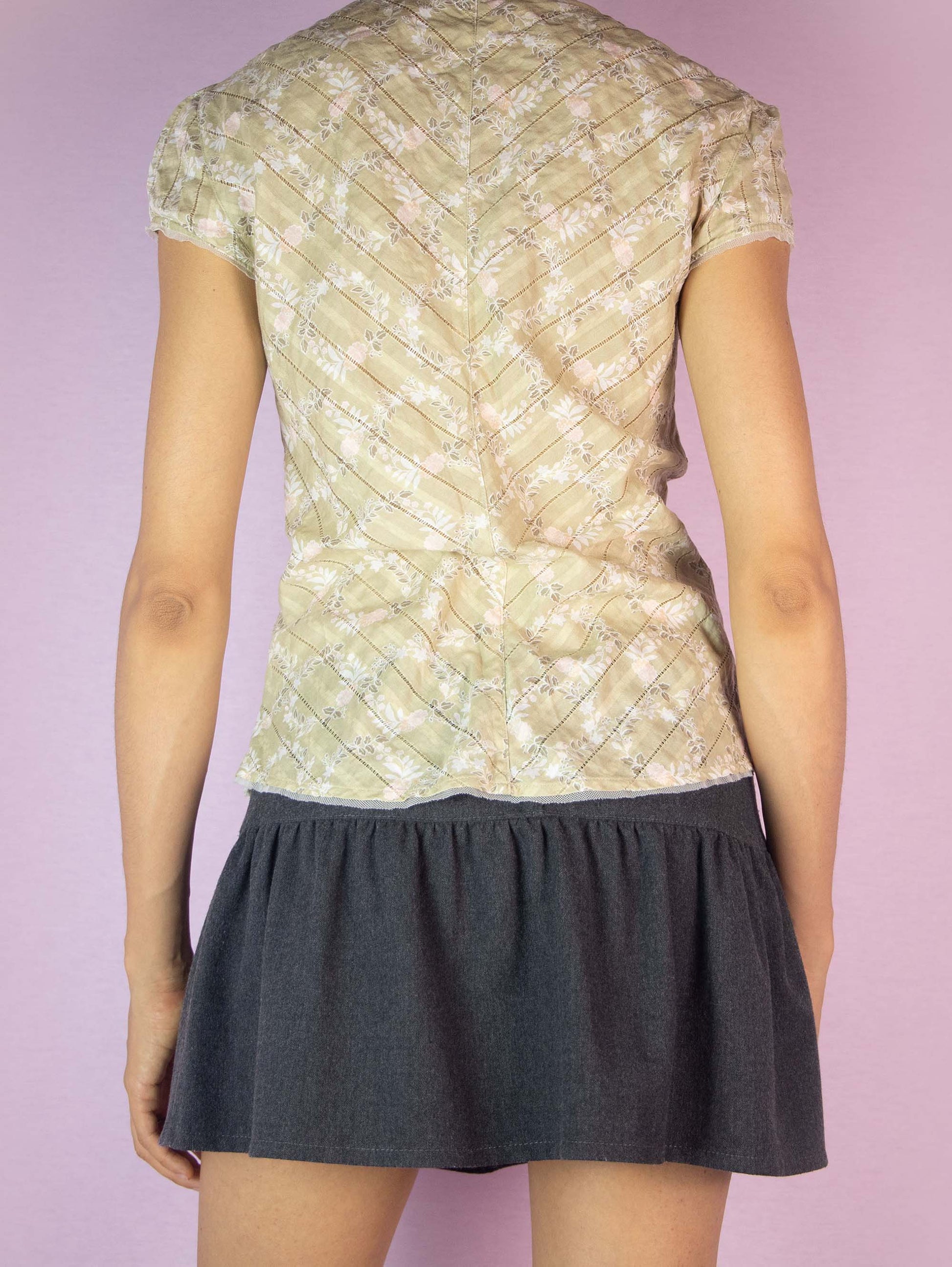 The Y2K Floral Print Cotton Blouse is a vintage 2000s beige, white, and pink top featuring a lightweight fabric, short sleeves, a v-neckline, and a relaxed fit, perfect for a casual summer look.