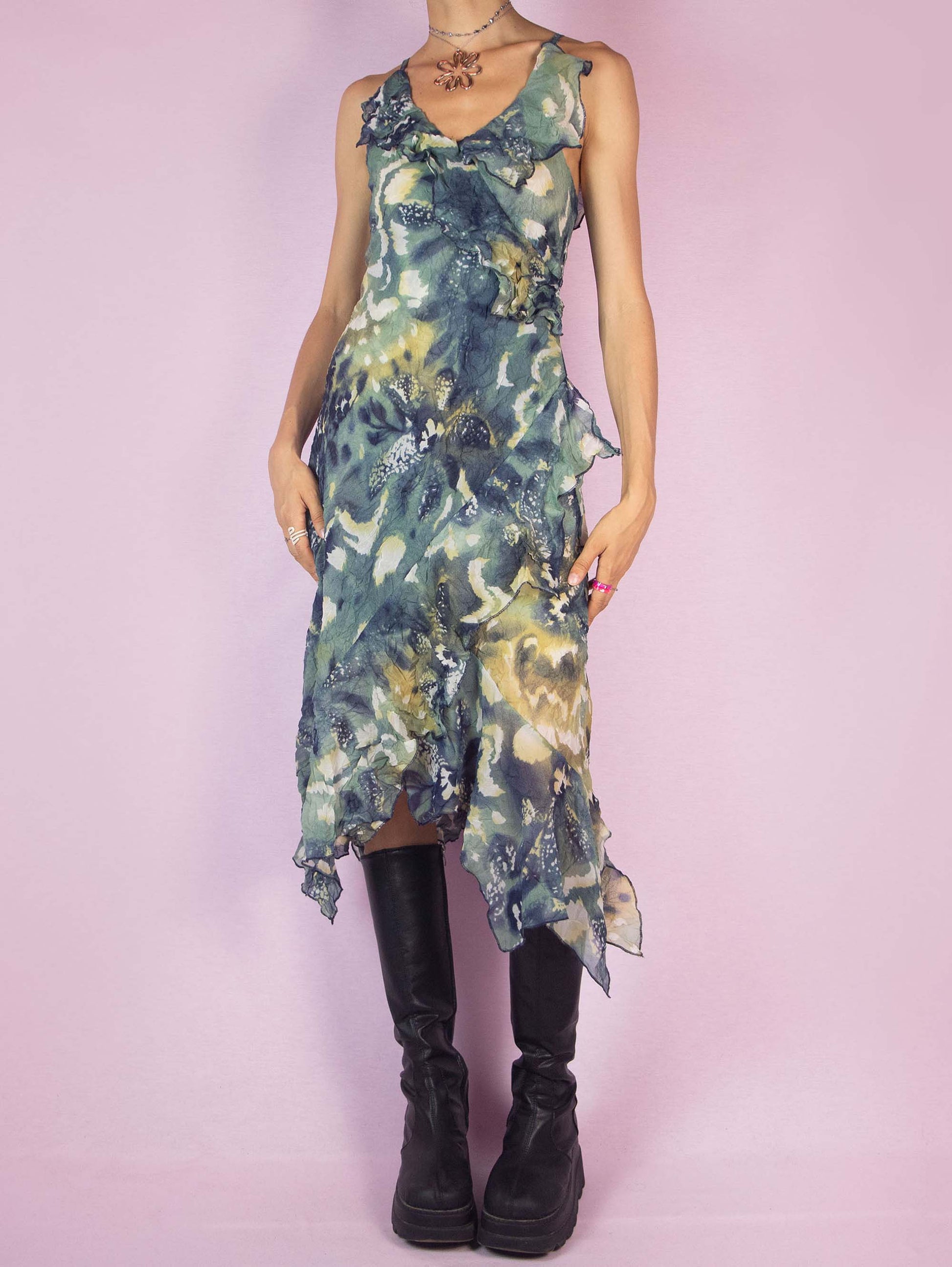 The Y2K Asymmetrical Ruffle Midi Dress is a vintage 2000s piece featuring an abstract print, delicate ruffle details along the neckline and hem, and an asymmetrical, flowy silhouette. Perfect for summer parties, evening outings, or a romantic day out.