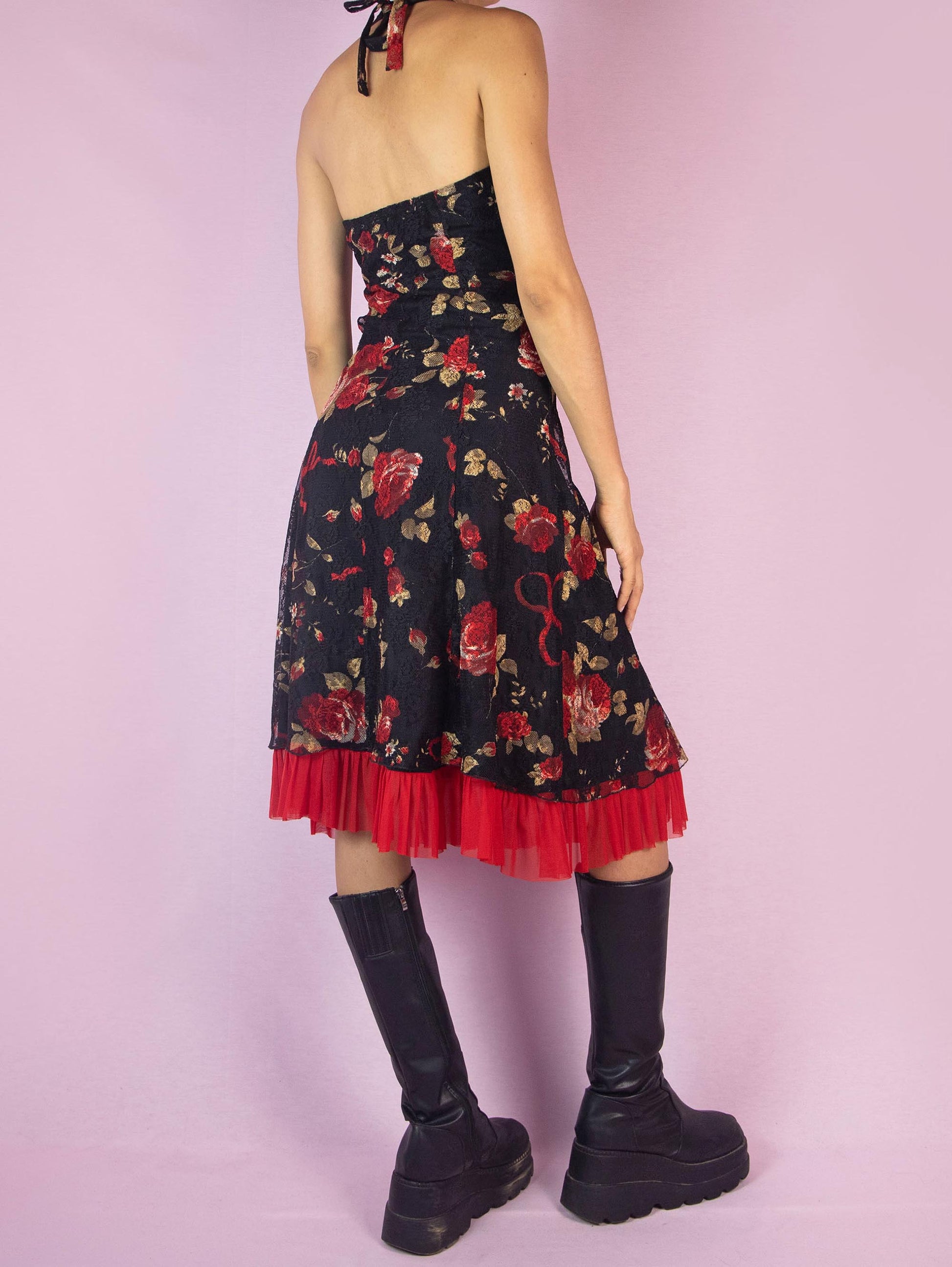 The Y2K Black Halter Lace Midi Dress is a vintage 2000s piece featuring a halter tie neck design, a red floral rose print mesh overlay, and a side zipper closure. Perfect for a summer party or a romantic evening out.