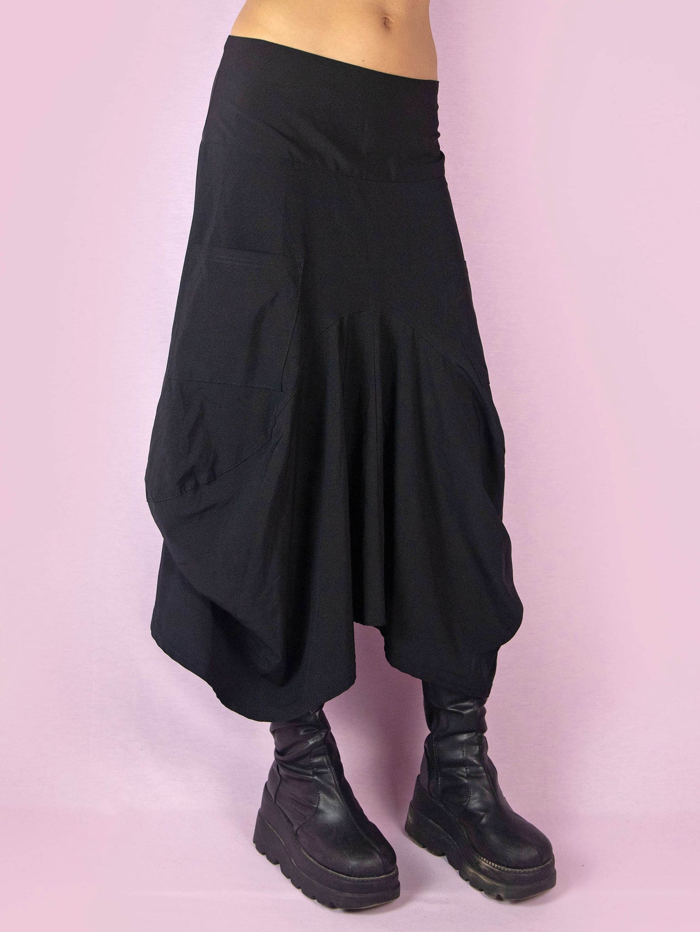 The Y2K Black Balloon Midi Skirt is a vintage 2000s avant-garde deconstructed subversive bubble-style skirt, slightly stretchy, with pockets, pleats, an asymmetrical hem, and a back zipper closure. Made in France.