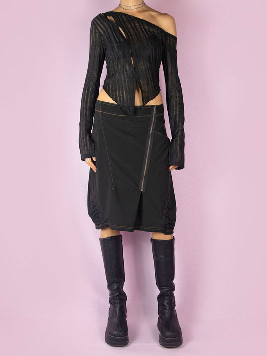 The Y2K Black Subversive Midi Skirt is a vintage 2000s avant-garde deconstructed skirt with pockets, contrast seam details, ruching at the hem, and a front zipper closure.