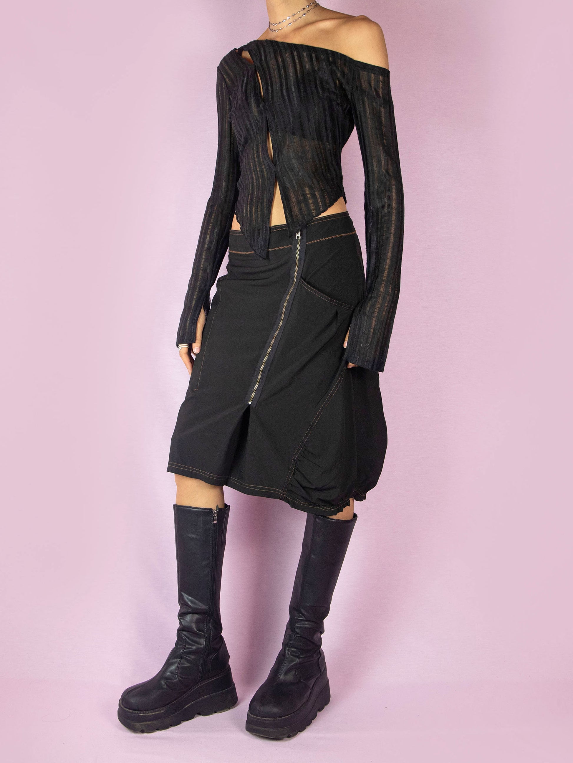 The Y2K Black Subversive Midi Skirt is a vintage 2000s avant-garde deconstructed skirt with pockets, contrast seam details, ruching at the hem, and a front zipper closure.