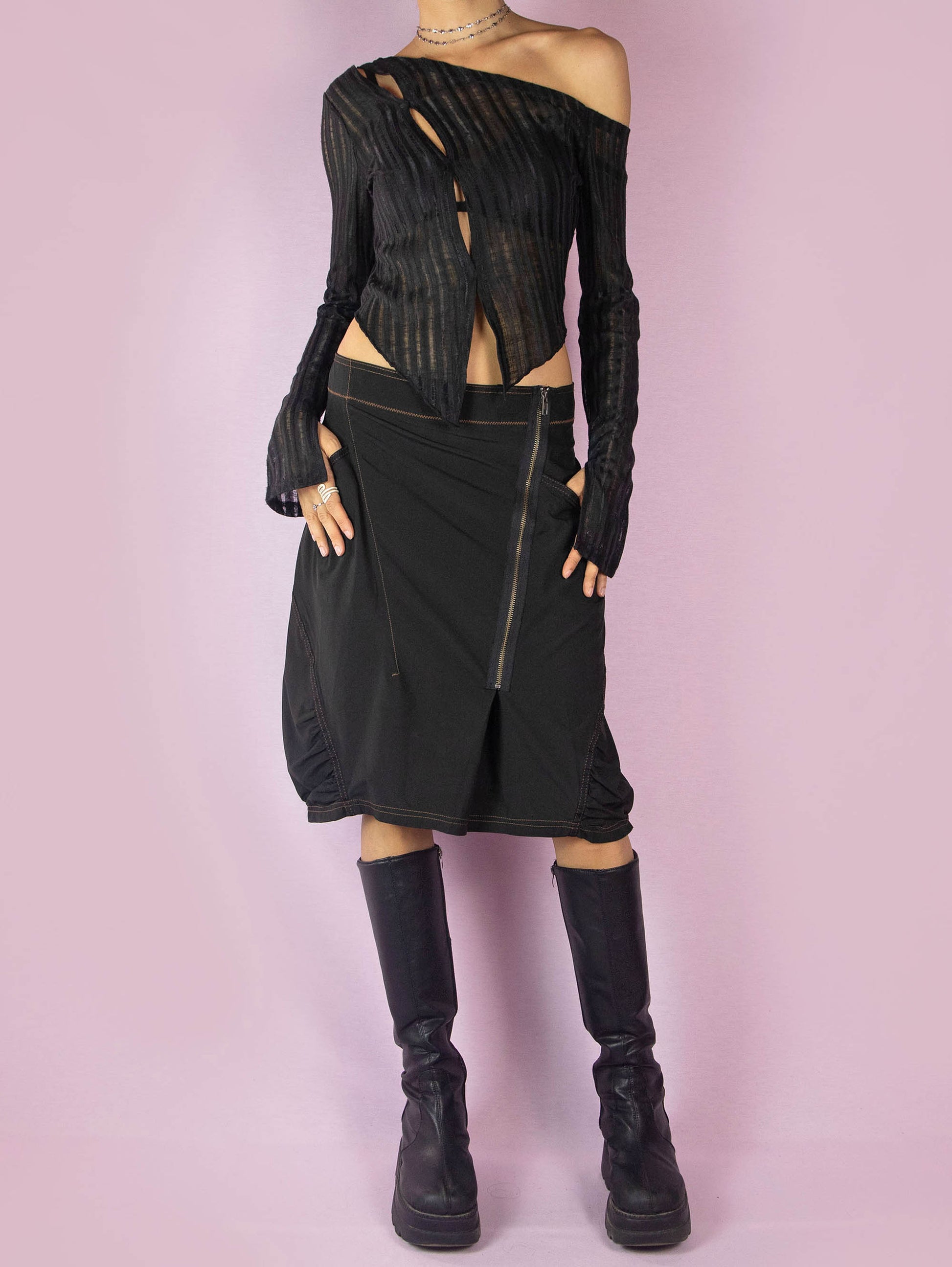 The Y2K Black Subversive Midi Skirt is a vintage 2000s avant-garde deconstructed skirt with pockets, contrast seam details, ruching at the hem, and a front zipper closure.