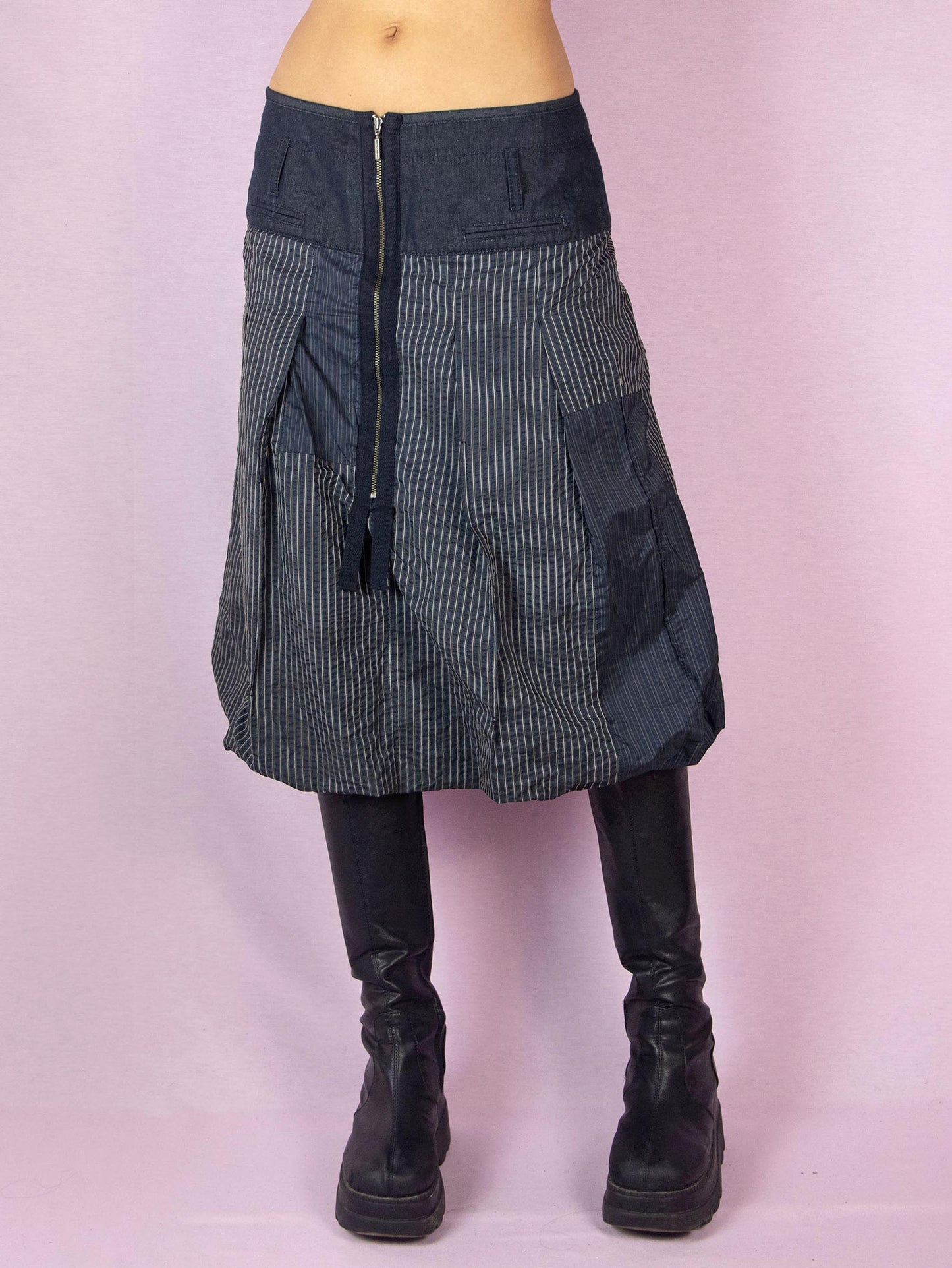 The Y2K Blue Balloon Midi Skirt is a dark navy blue vintage 2000s avant-garde subversive bubble style skirt with a pinstripe pattern and front zipper closure.