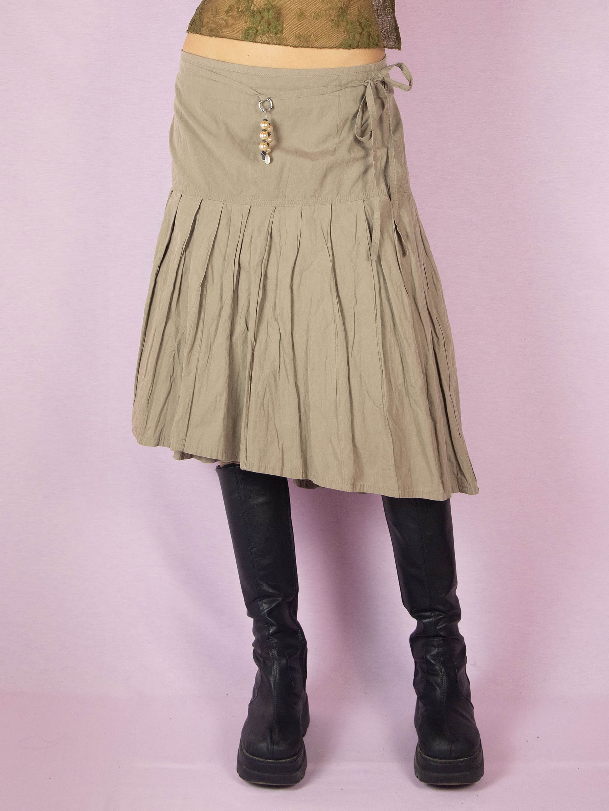 The Y2K Khaki Pleated Midi Skirt is a vintage 2000s casual minimalist beige circle A-line skirt with a back zipper closure and matching belt.