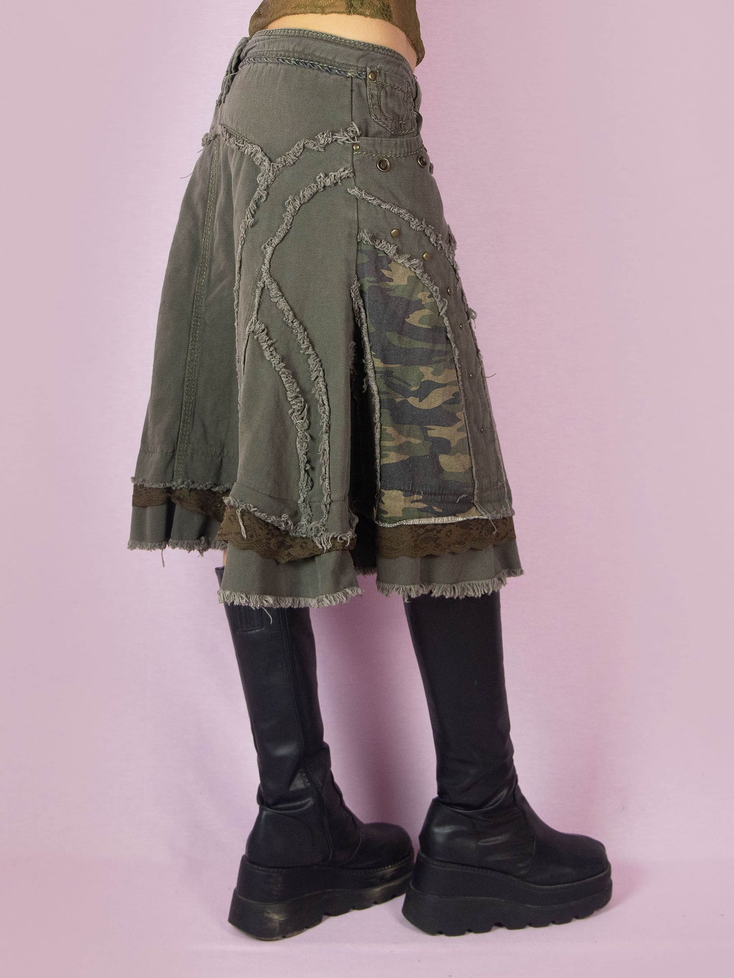 The Y2K Khaki Denim Midi Skirt is a green vintage 2000s avant-garde subversive deconstructed skirt with stud details, lace, camouflage print, ruffle hem, and frayed seams.