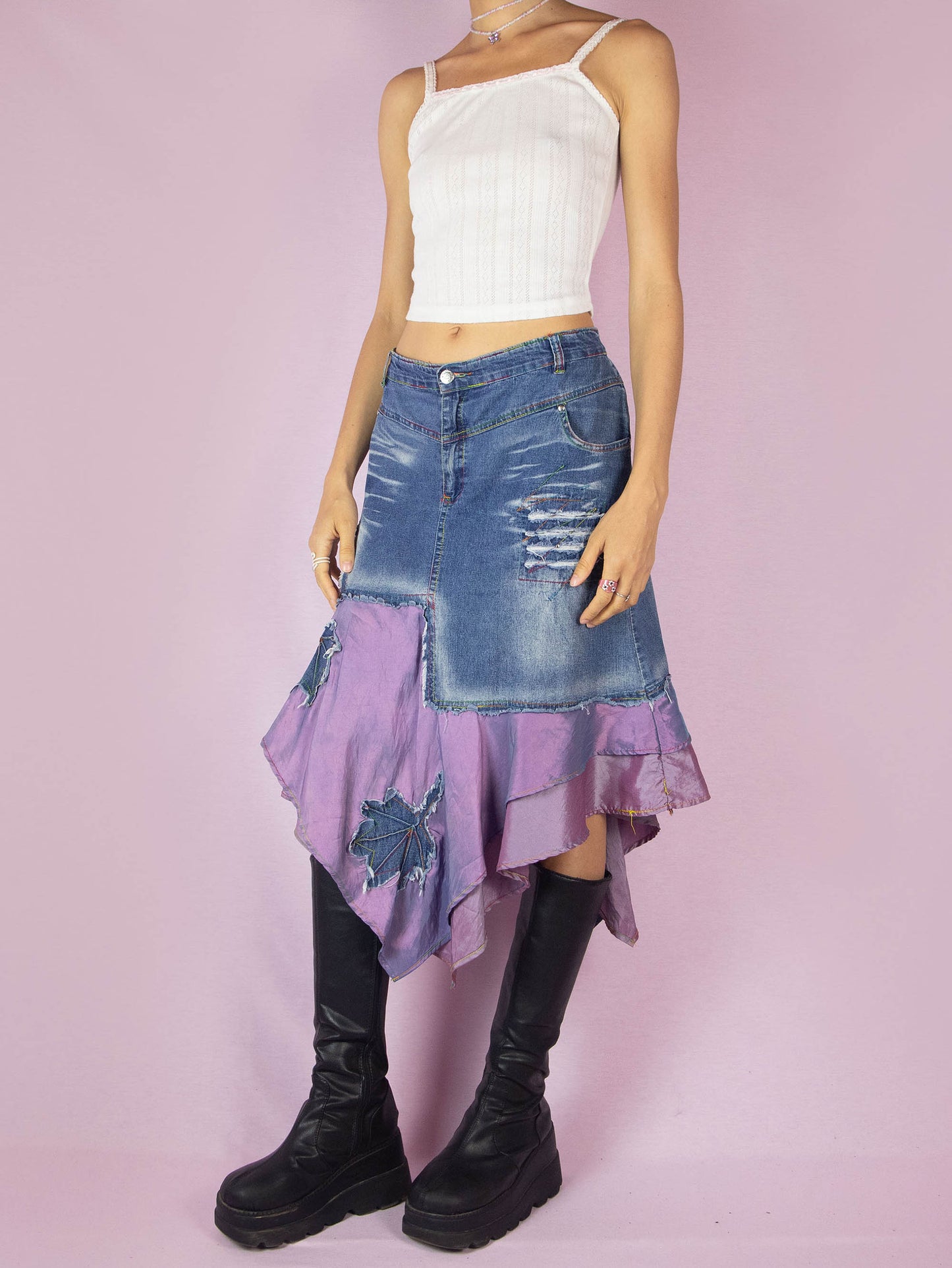The Y2K Denim Asymmetric Trumpet Skirt is a vintage 2000s slightly stretchy jean midi skirt, avant-garde and deconstructed, with applique and acid wash details, a layered pointed hem, pockets, and a zipper closure.