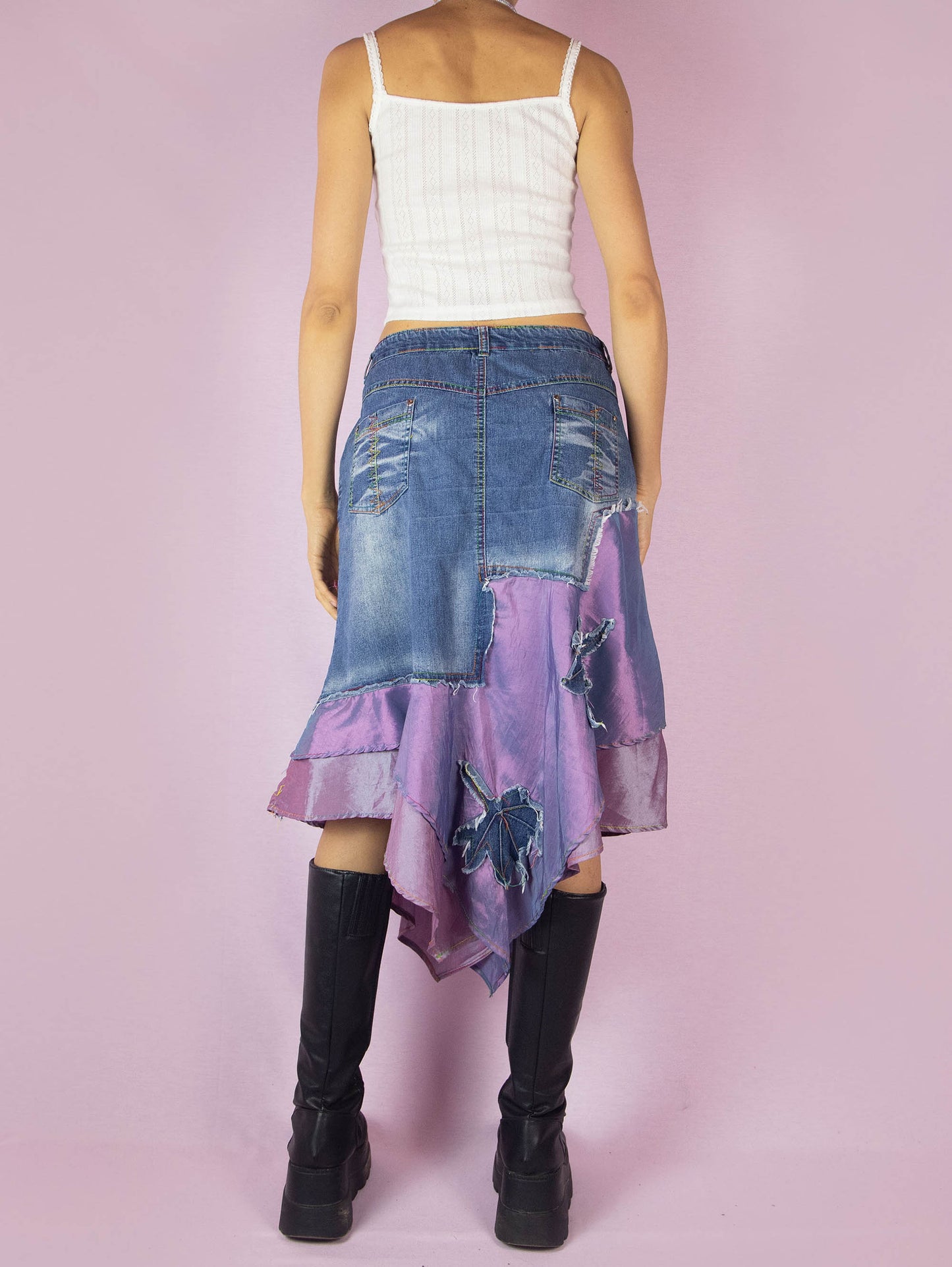 The Y2K Denim Asymmetric Trumpet Skirt is a vintage 2000s slightly stretchy jean midi skirt, avant-garde and deconstructed, with applique and acid wash details, a layered pointed hem, pockets, and a zipper closure.