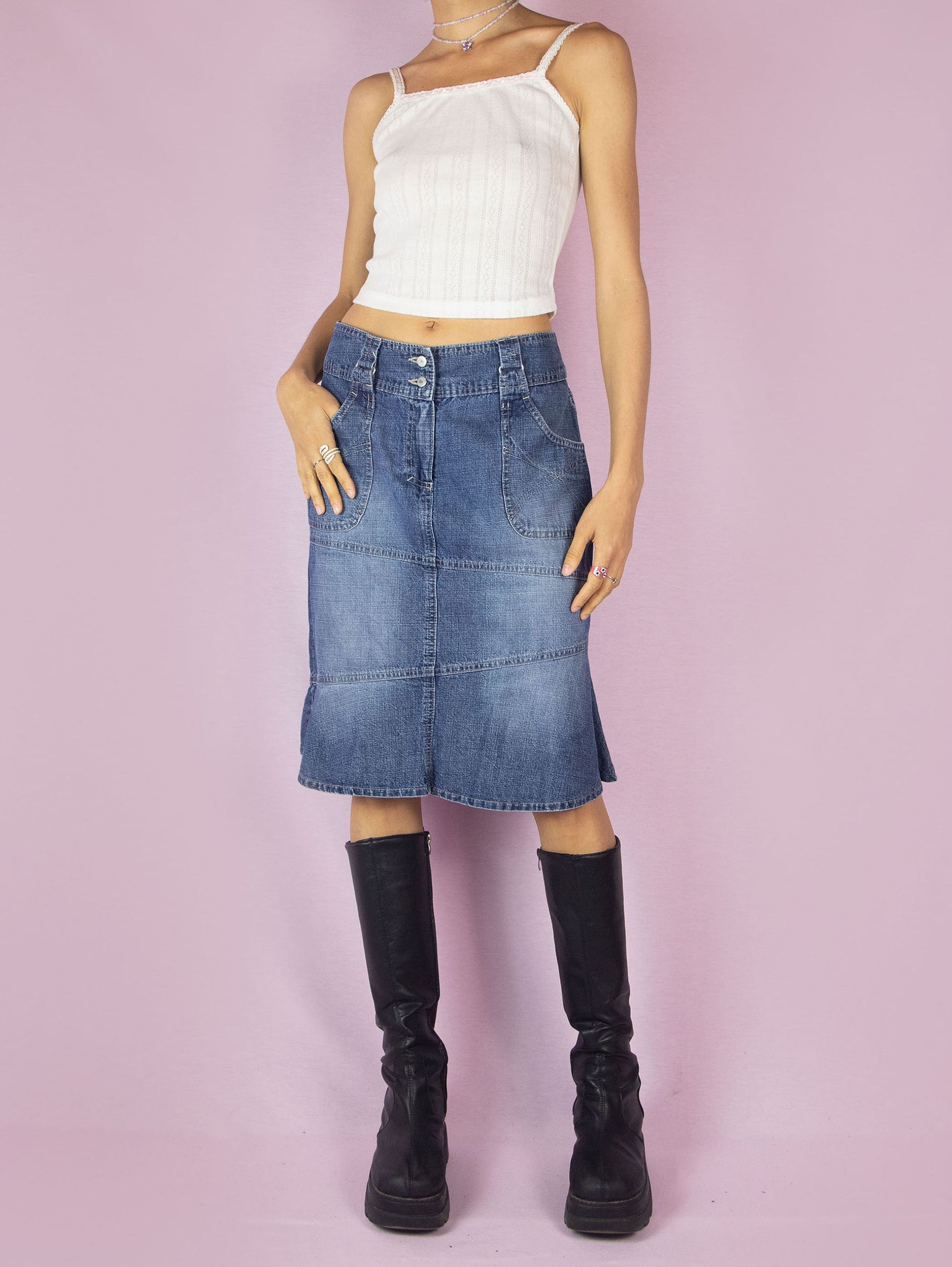 The Y2K Midi Trumpet Denim Skirt is a vintage 2000s paneled jean skirt in a streetwear grunge style with pockets, a front zipper closure, and a ruffle hem.