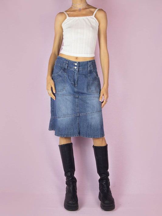 The Y2K Midi Trumpet Denim Skirt is a vintage 2000s paneled jean skirt in a streetwear grunge style with pockets, a front zipper closure, and a ruffle hem.