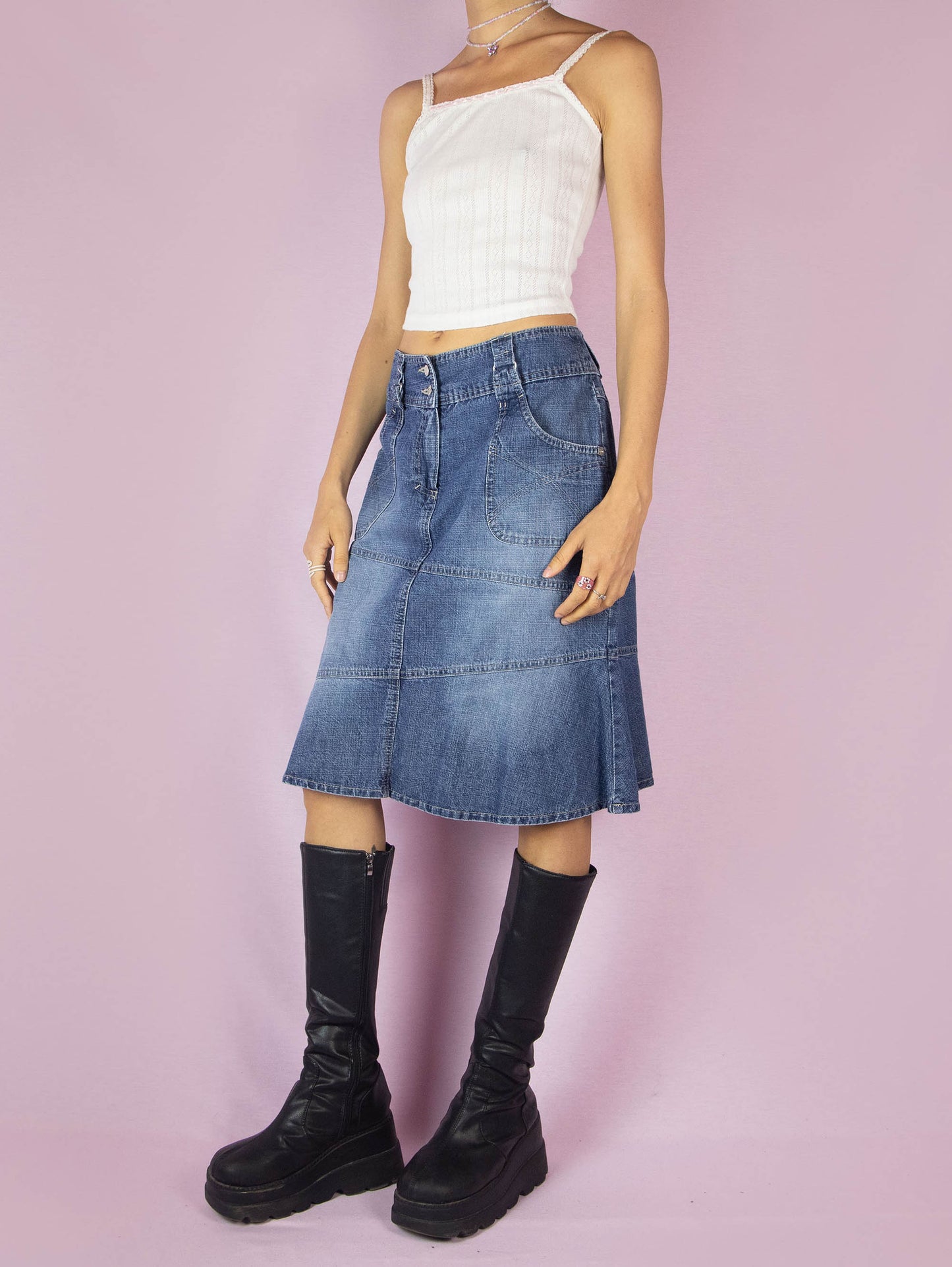 The Y2K Midi Trumpet Denim Skirt is a vintage 2000s paneled jean skirt in a streetwear grunge style with pockets, a front zipper closure, and a ruffle hem.