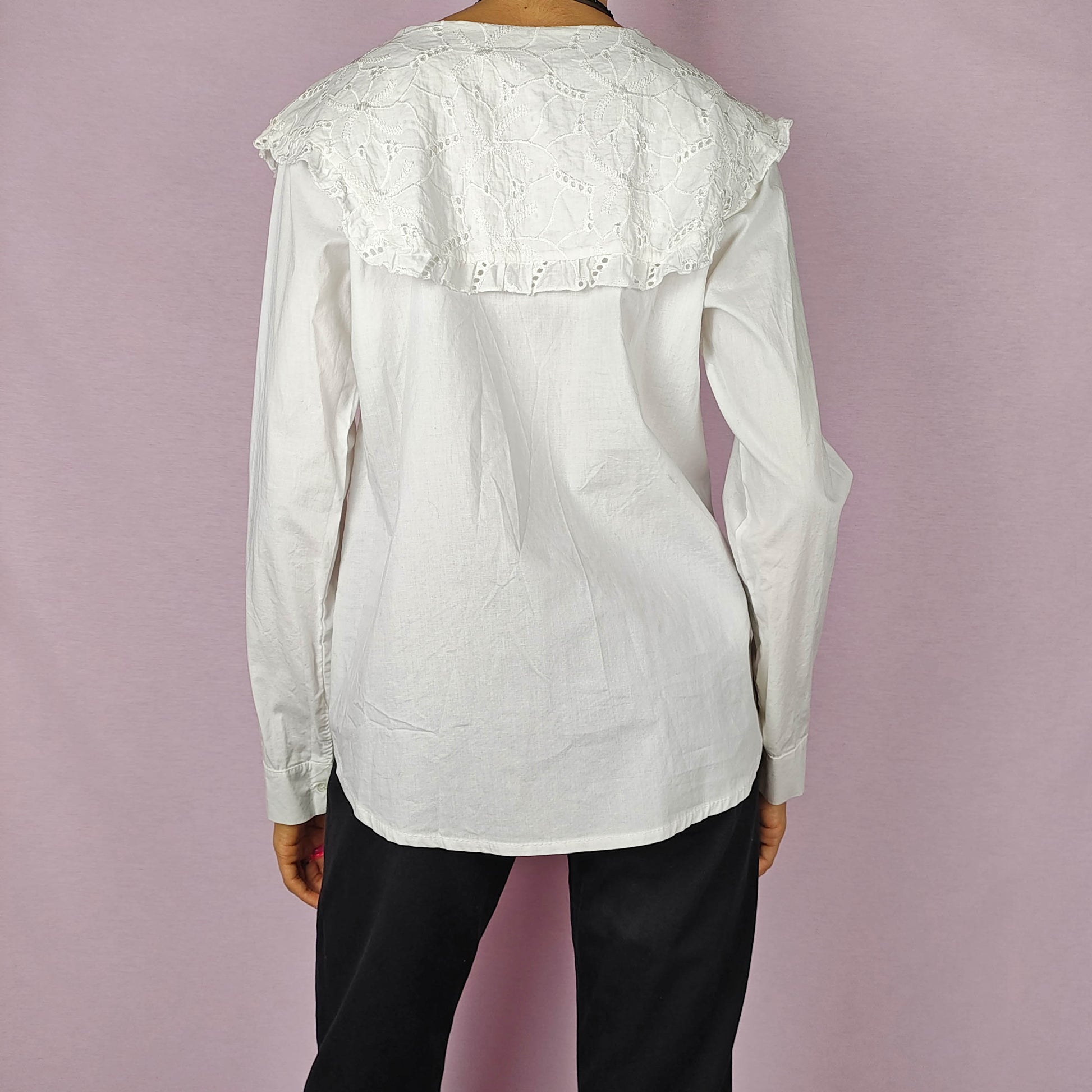 The Y2K Lace Collar White Blouse is a vintage 2000s shirt featuring an oversized lace collar in a delicate cream tone, long sleeves and a button-up front. Ideal for both casual and elegant formal wear.