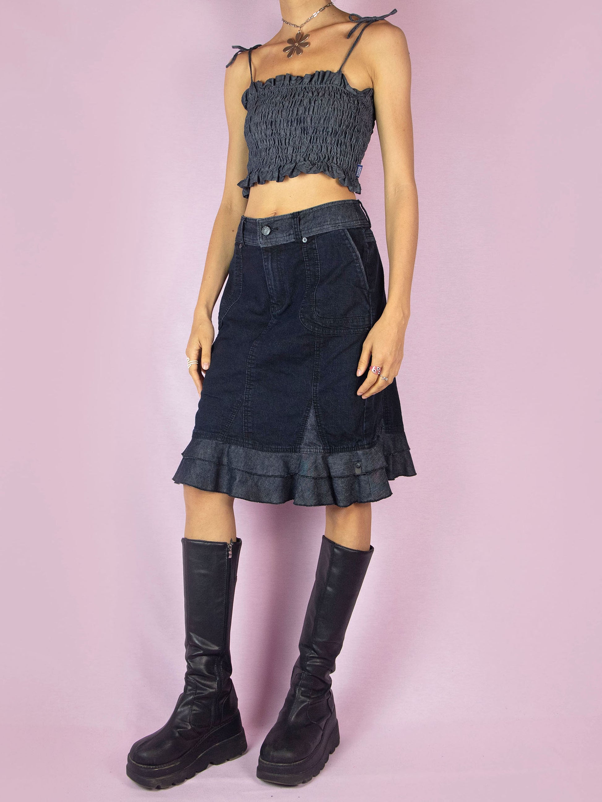 The Y2K Dark Denim Trumpet Skirt is a slightly stretchy vintage 2000s jean midi skirt with a pocket, front zipper closure, and a ruffle hem.