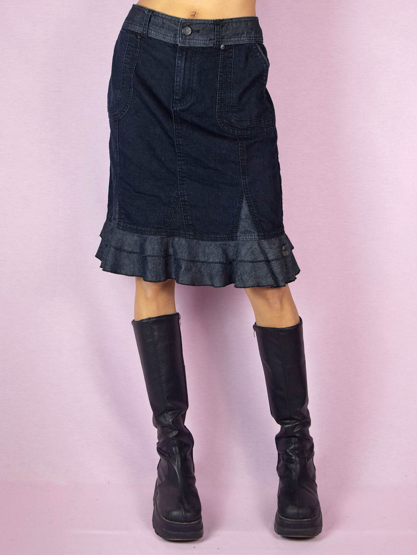 The Y2K Dark Denim Trumpet Skirt is a slightly stretchy vintage 2000s jean midi skirt with a pocket, front zipper closure, and a ruffle hem.