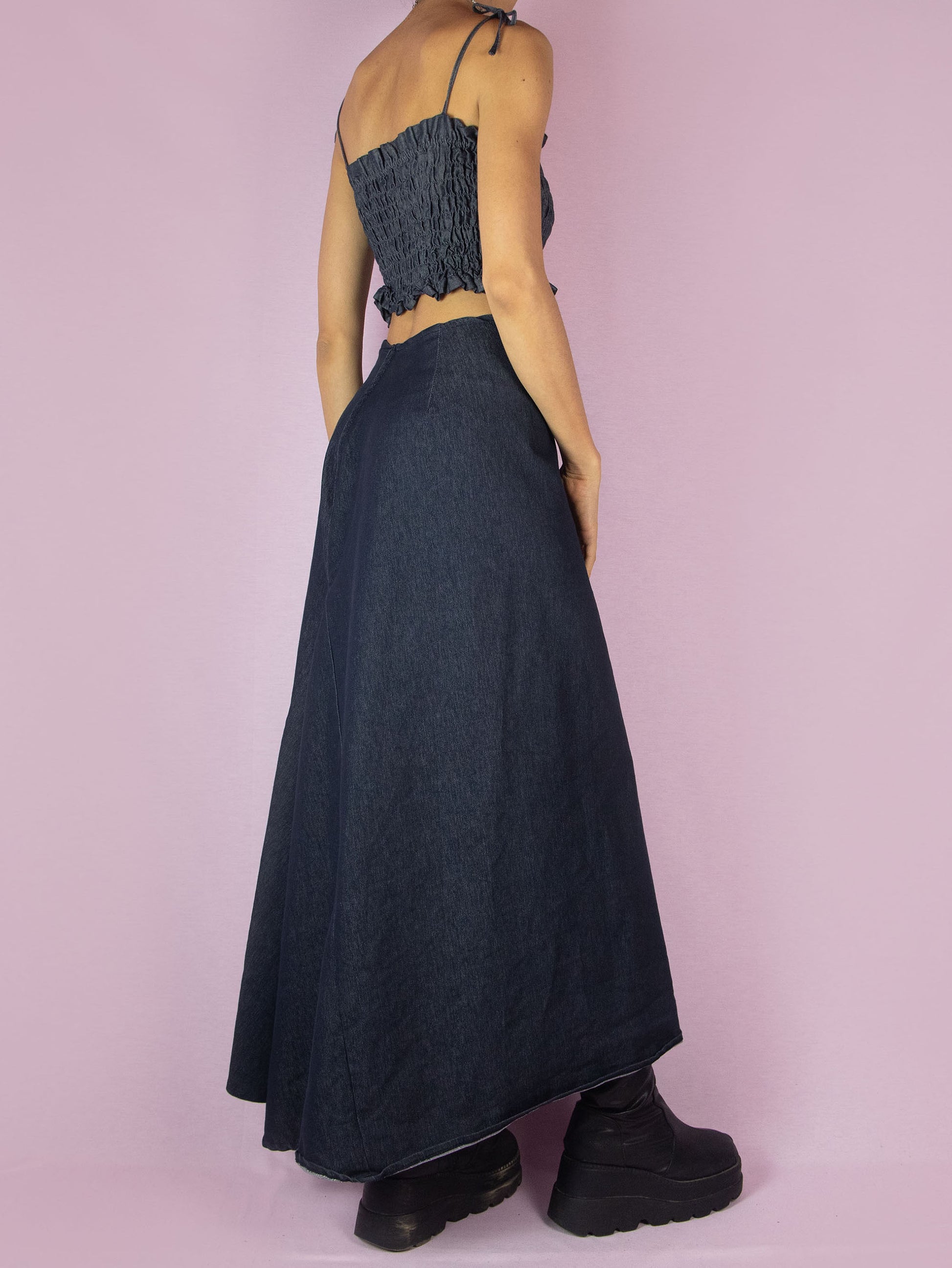 The Y2K Denim Asymmetric Maxi Skirt is a stretchy dark jean vintage 2000s subversive deconstructed A-line midi skirt with a back zipper closure.