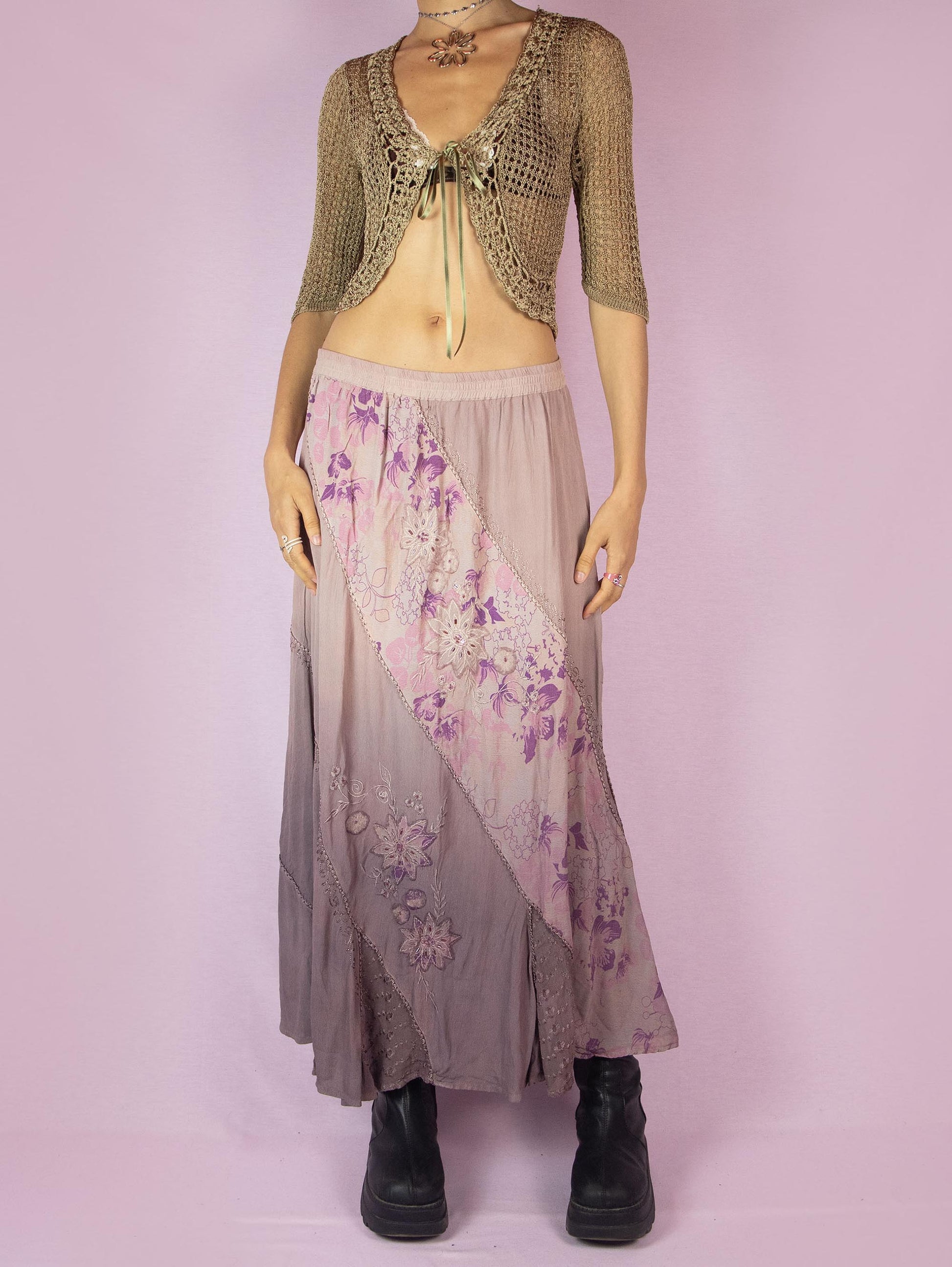 The Vintage 90s Purple A Line Midi Skirt is a dusty pinkish-purple ombre pattern boho maxi skirt with adorned with embroidered floral details, embellished with sequins and beads, and featuring an elastic waistband.