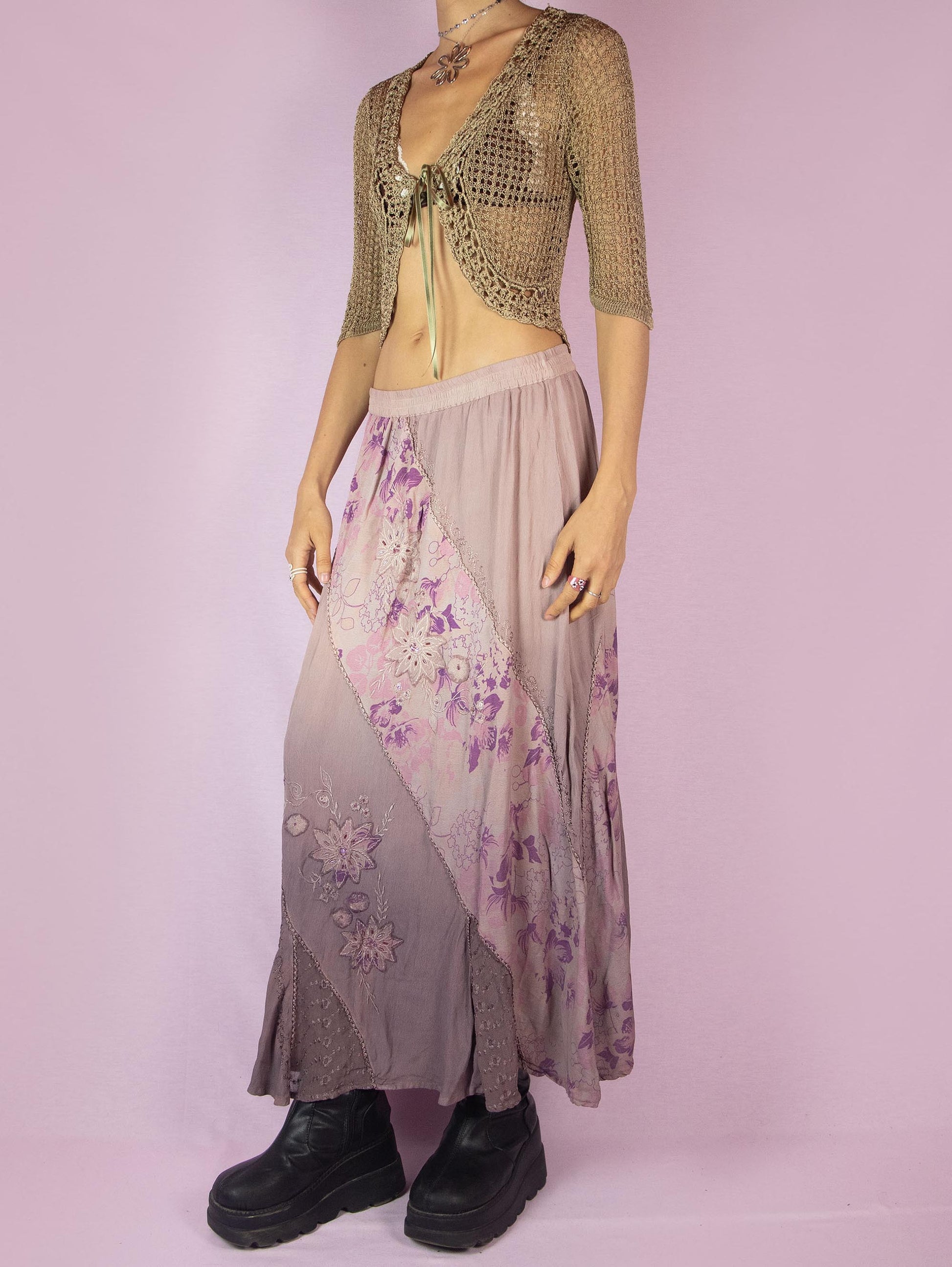 The Vintage 90s Purple A Line Midi Skirt is a dusty pinkish-purple ombre pattern boho maxi skirt with adorned with embroidered floral details, embellished with sequins and beads, and featuring an elastic waistband.