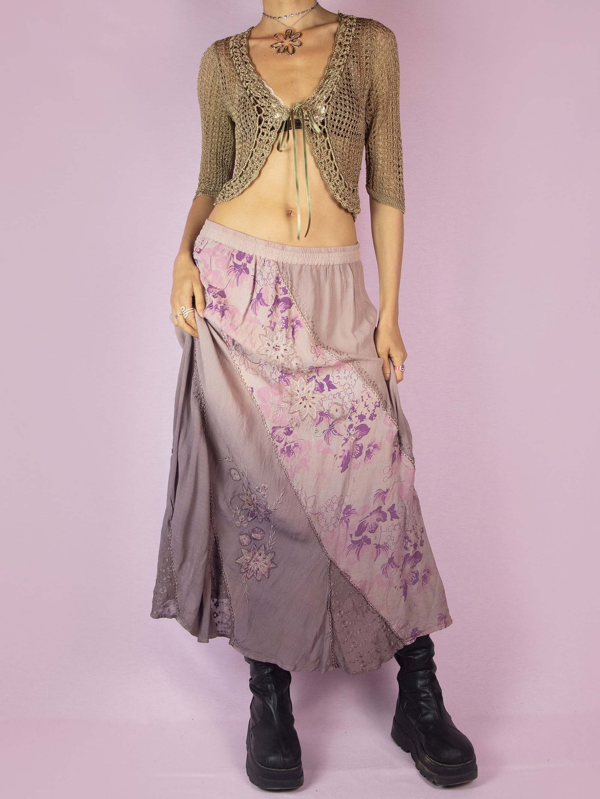 The Vintage 90s Purple A Line Midi Skirt is a dusty pinkish-purple ombre pattern boho maxi skirt with adorned with embroidered floral details, embellished with sequins and beads, and featuring an elastic waistband.