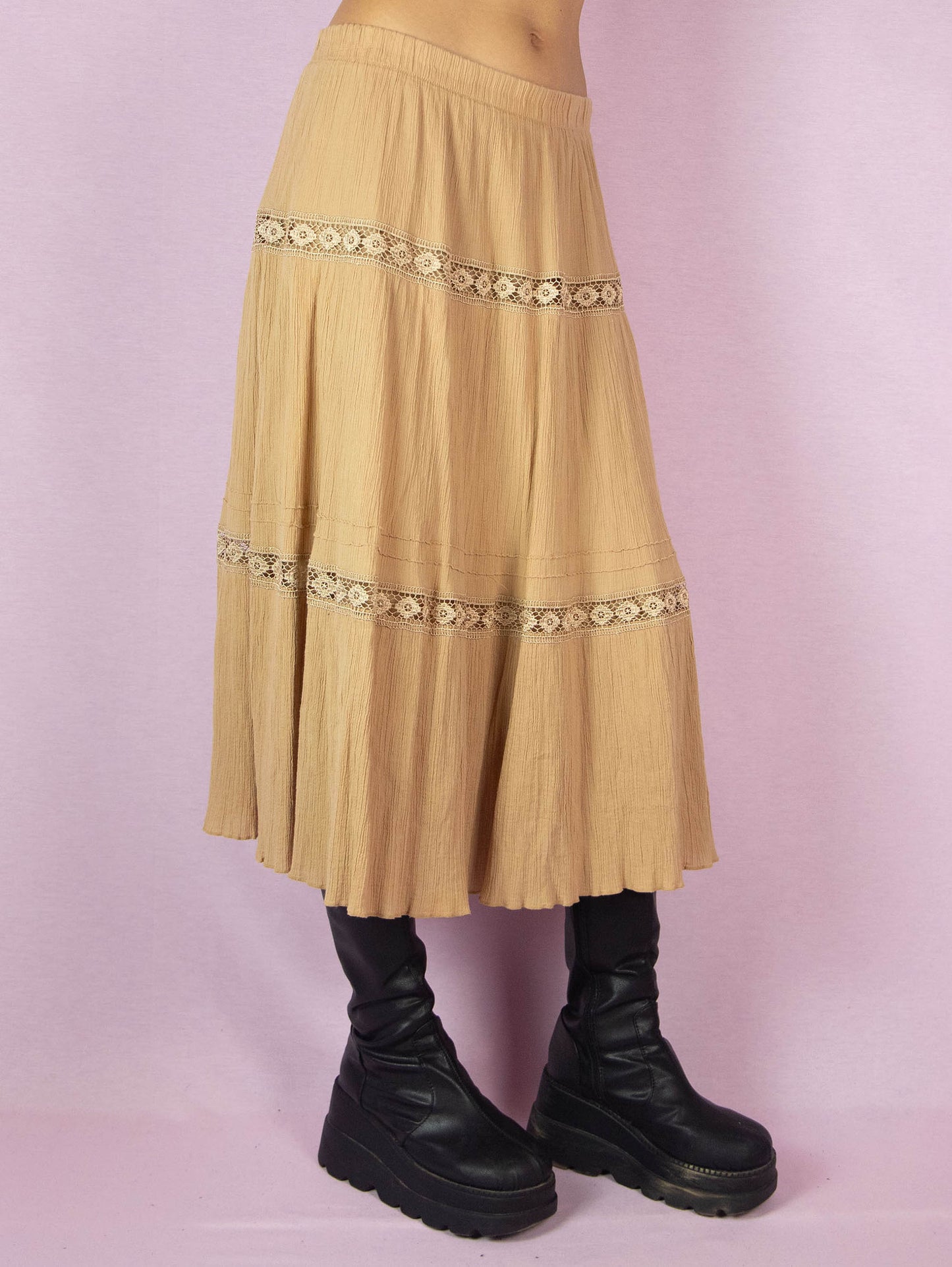 The Vintage 90s Beige Tiered Peasant Skirt is a boho midi circle skirt with an elastic waistband.