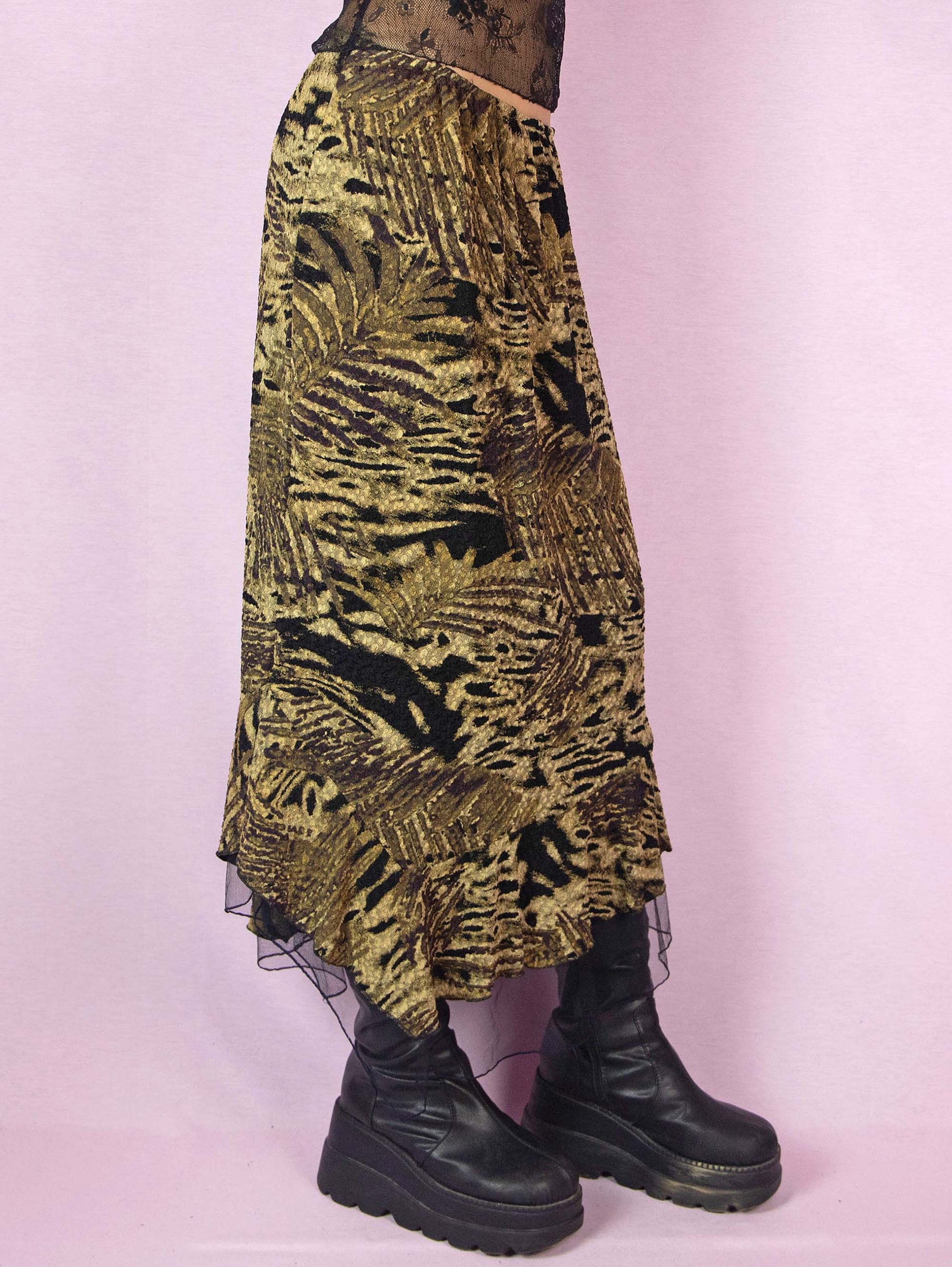 The Vintage 90s Asymmetric Trumpet Midi Skirt is an elastic party night skirt with a textured multicolor abstract print, an elastic waistband, and a black tulle ruffle hem.