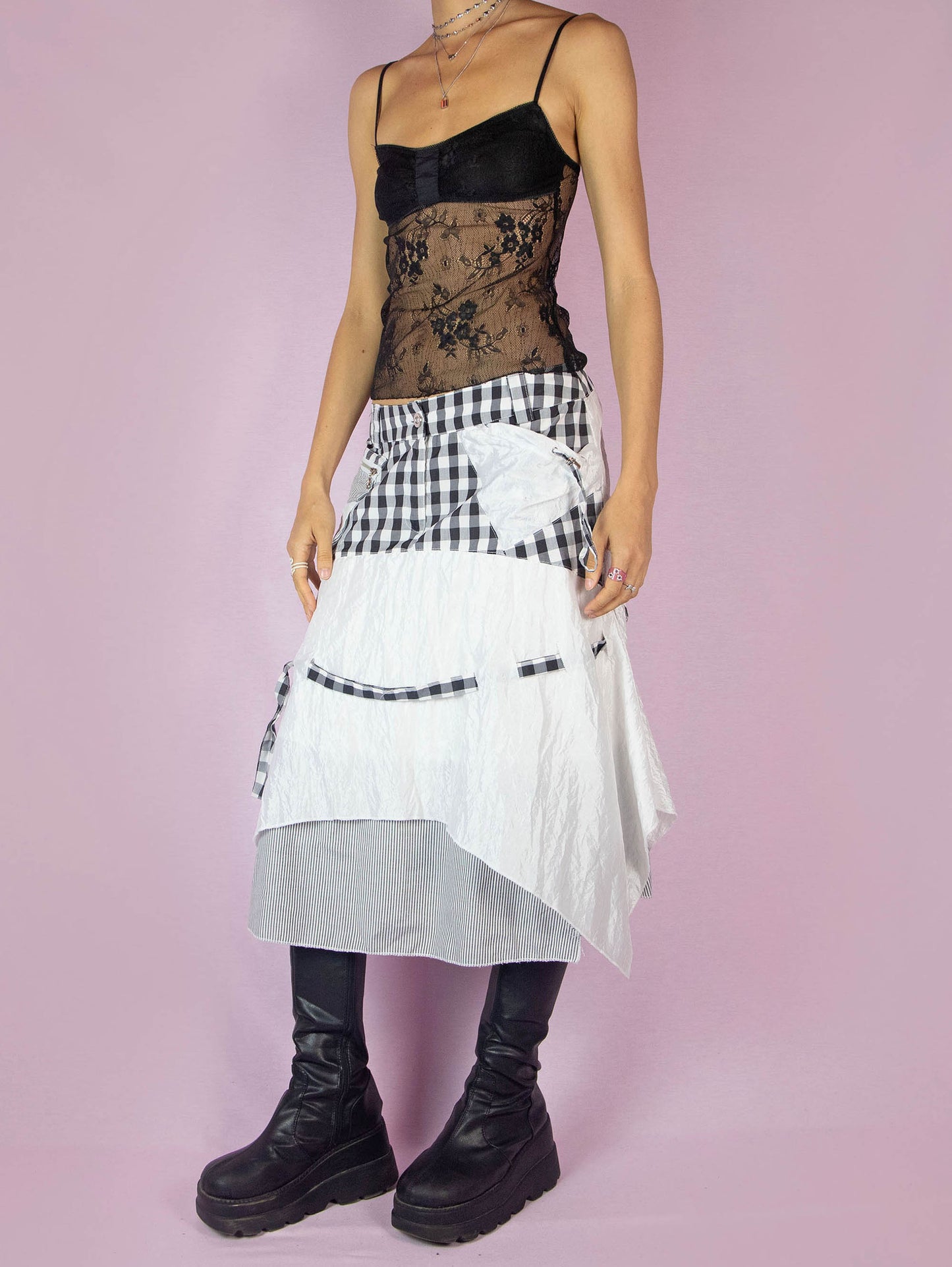 The Y2K Layered Handkerchief Midi Skirt is a vintage 2000s deconstructed subversive black and white skirt with a check plaid and stripe print, pockets, front zipper closure, and an asymmetrical hem.