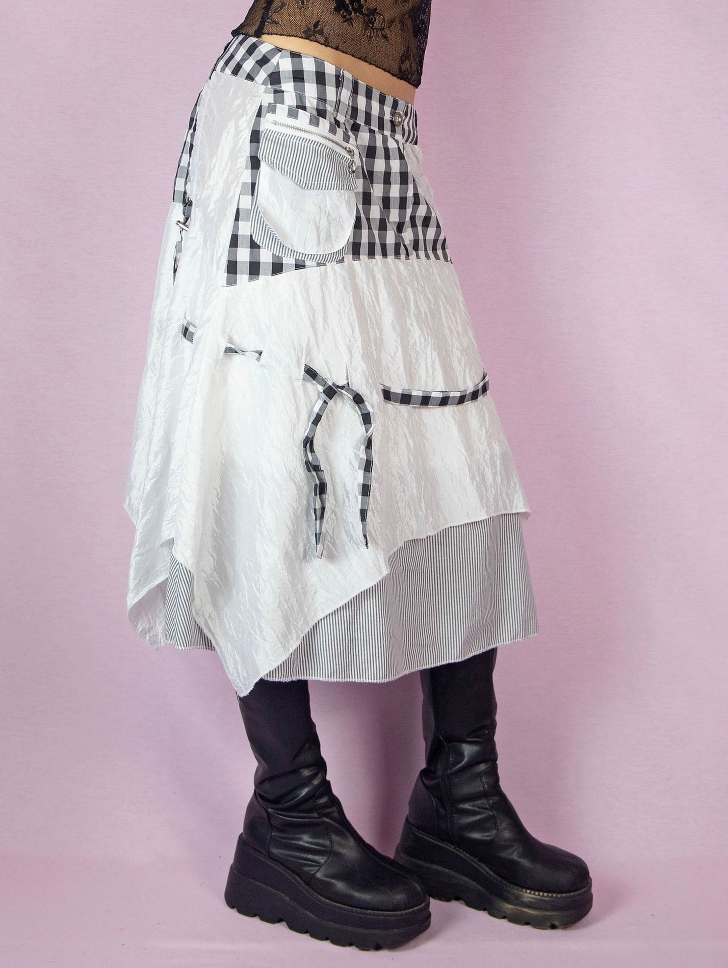 The Y2K Layered Handkerchief Midi Skirt is a vintage 2000s deconstructed subversive black and white skirt with a check plaid and stripe print, pockets, front zipper closure, and an asymmetrical hem.