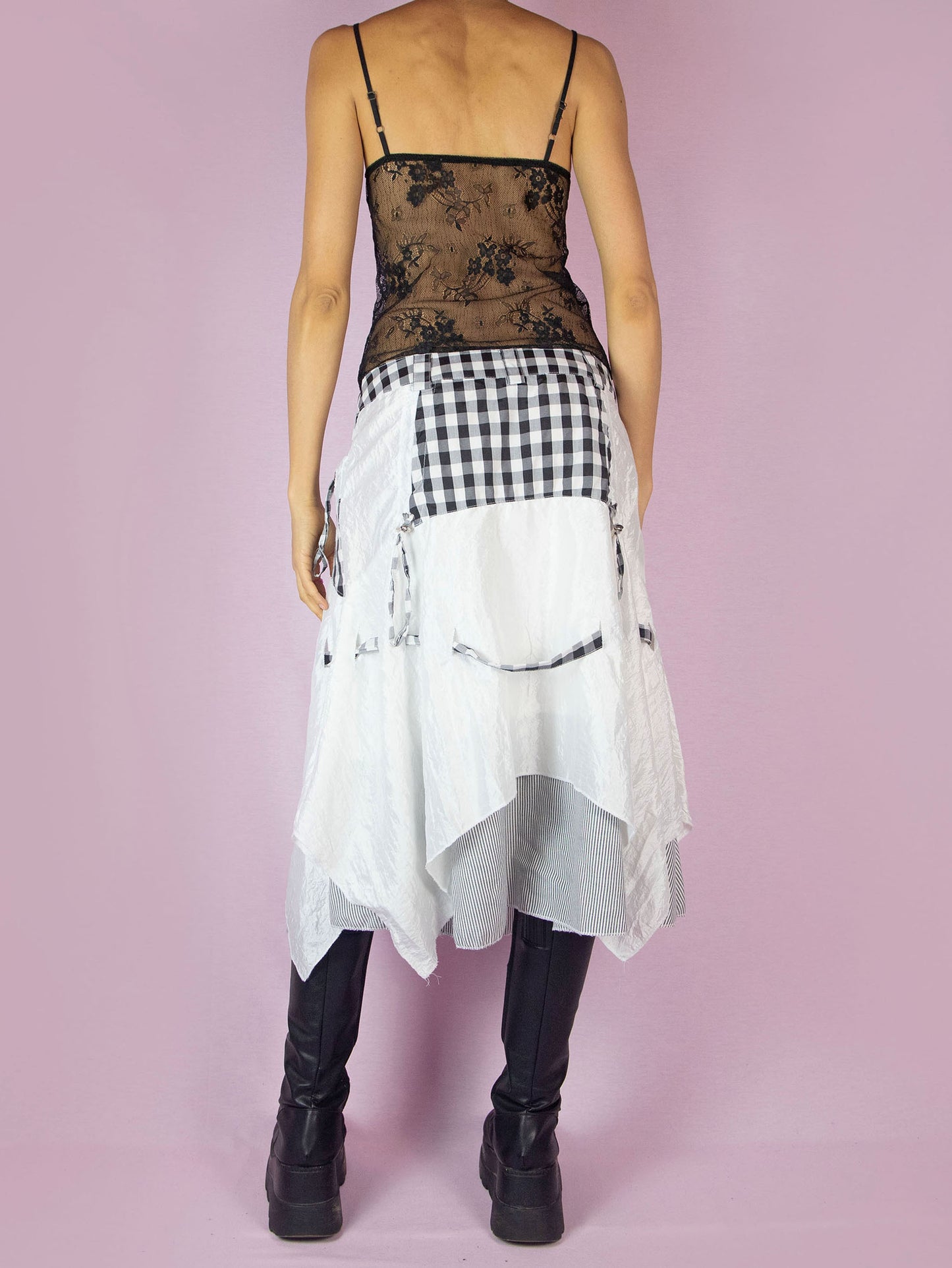 The Y2K Layered Handkerchief Midi Skirt is a vintage 2000s deconstructed subversive black and white skirt with a check plaid and stripe print, pockets, front zipper closure, and an asymmetrical hem.