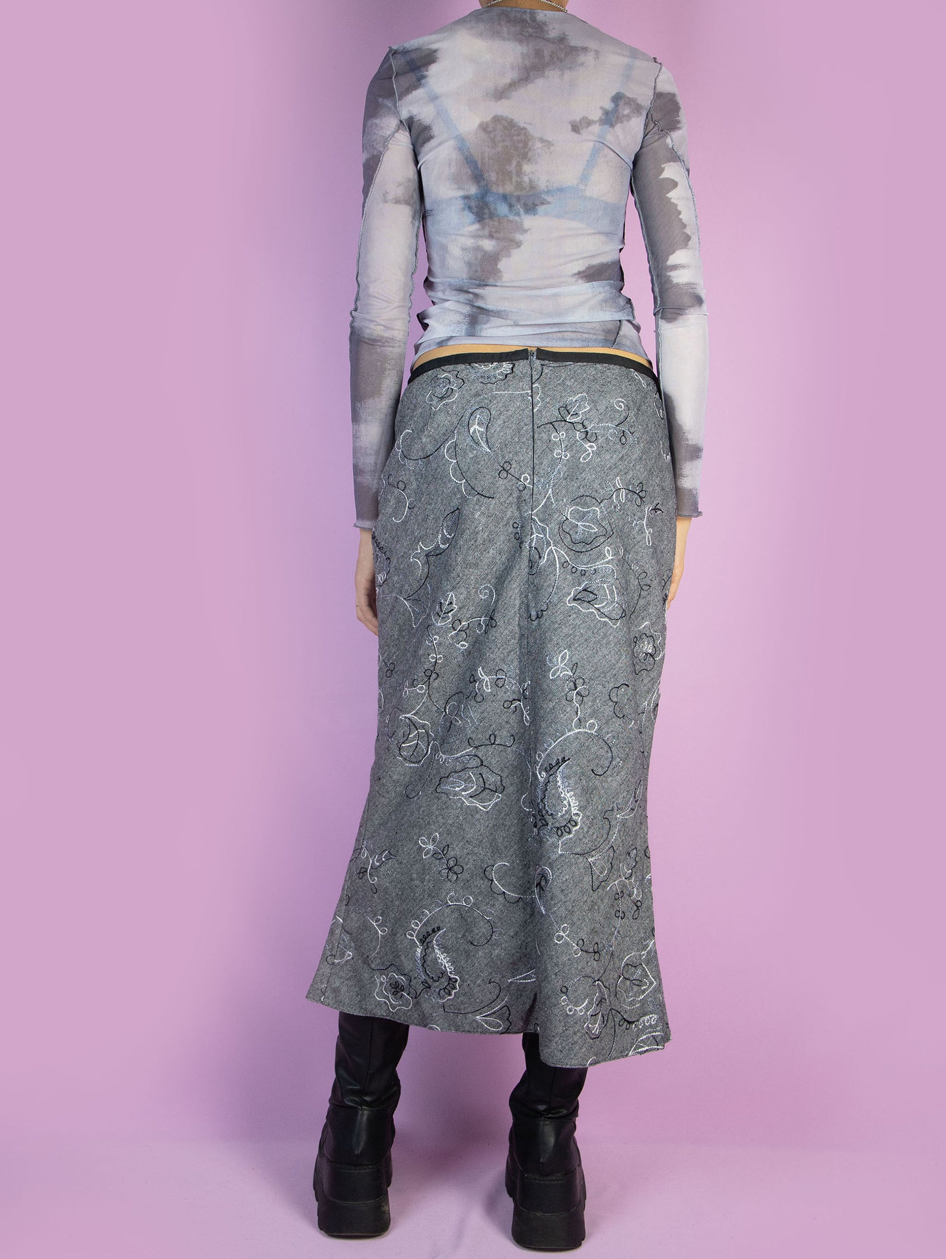 The Vintage 90s Gray Trumpet Midi Skirt is a boho fairy grunge inspired knitted skirt with embroidered floral paisley details and a back zipper closure. Excellent vintage condition.