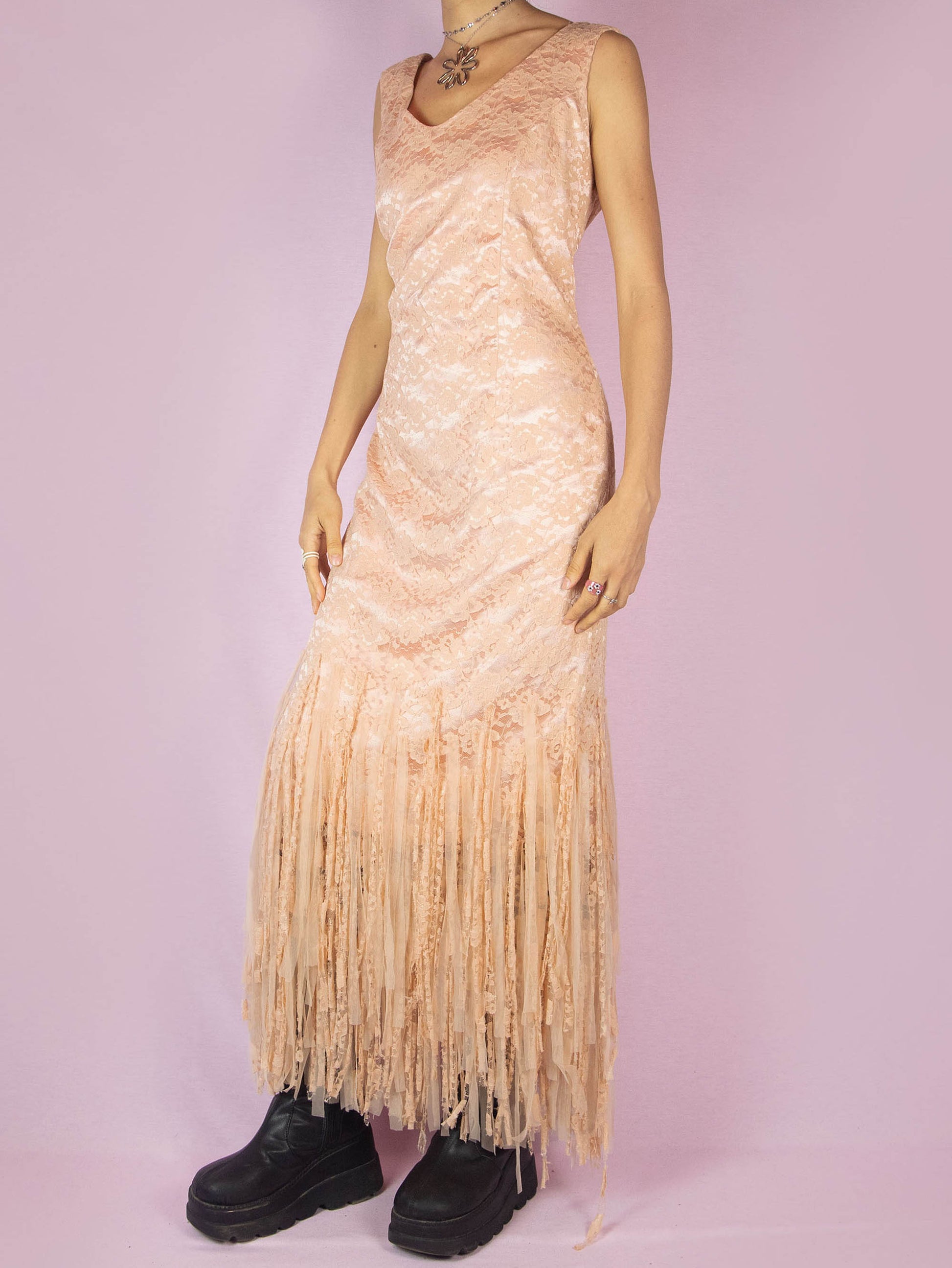 The Y2K Pink Lace Maxi Dress is a vintage 2000s romantic light salmon pink sleeveless party flapper dress with a side zipper closure and a tulle mesh fringed hem. Made in Spain.