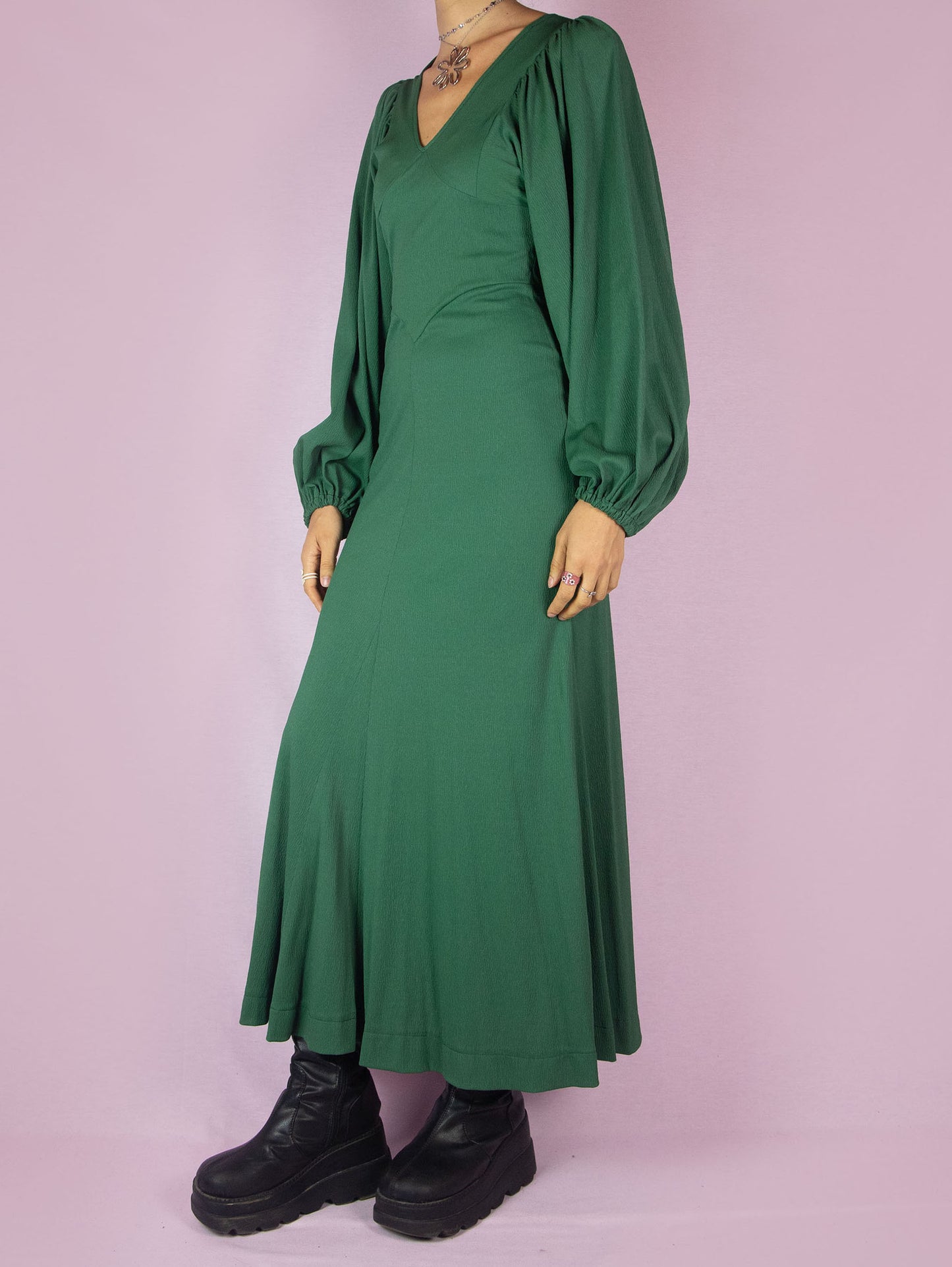 The Vintage 70s Green Maxi Dress is a slightly stretchy, romantic prairie country western-inspired elegant party midi dress with a V-neck, balloon sleeves, fitted waist, and back zipper closure.