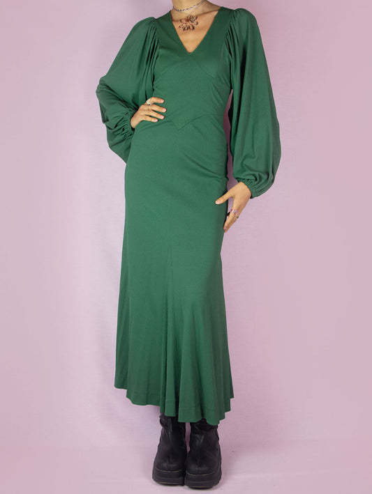 The Vintage 70s Green Maxi Dress is a slightly stretchy, romantic prairie country western-inspired elegant party midi dress with a V-neck, balloon sleeves, fitted waist, and back zipper closure.