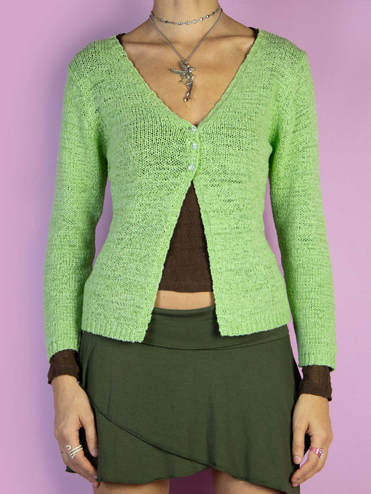 The Y2K Green Split Hem Cardigan is a vintage 2000s knit sweater featuring a front split, V-neck, three-quarter sleeves, and a three-button closure. Perfect for a casual autumn outfit.