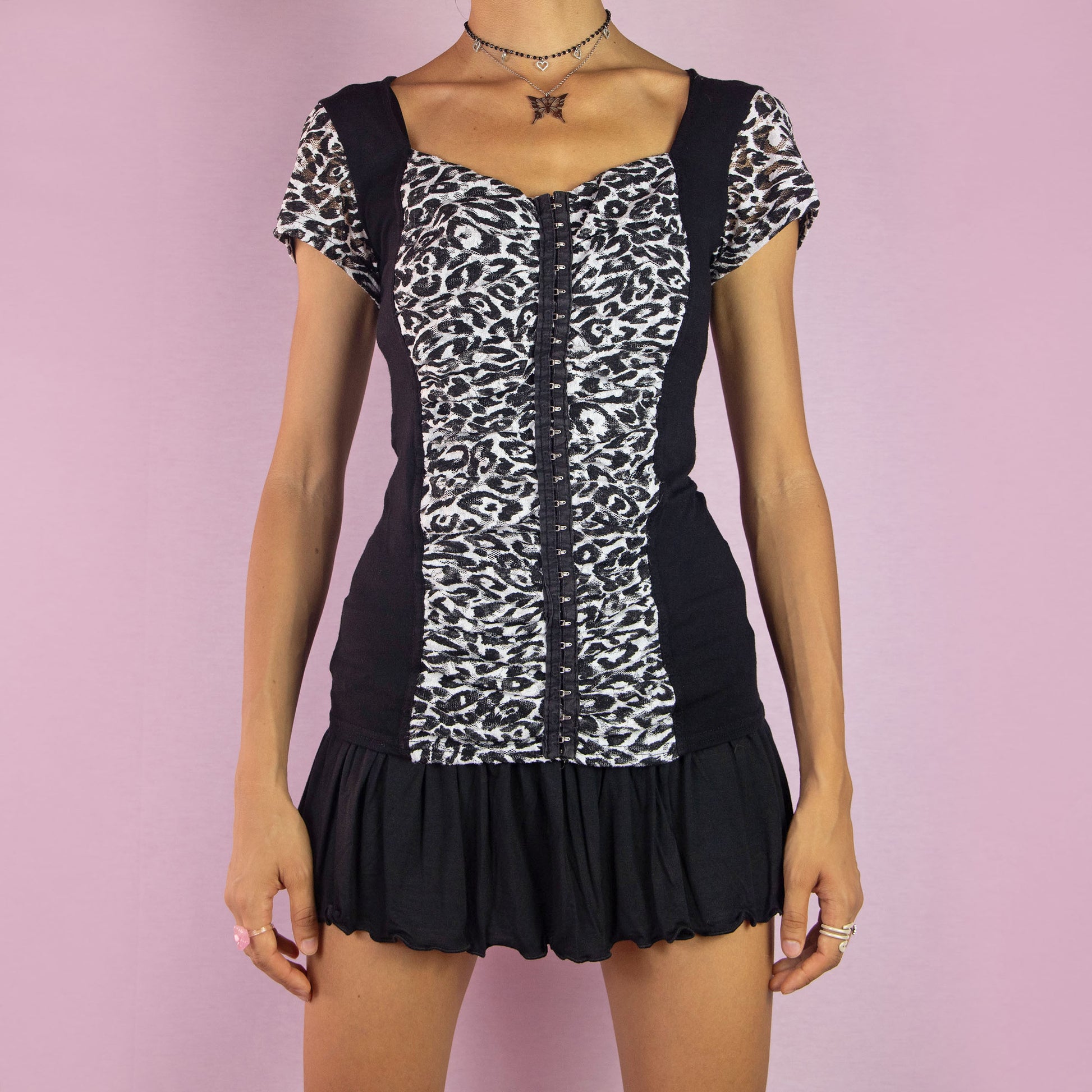 The Y2K Black Ruched Gathered Top by Morgan De Toi is a vintage 2000s blouse featuring a leopard animal print mesh, a ruched front panel, cap sleeves, and a hook and eye closure. Perfect for your casual or night-out wardrobe. Made in France.