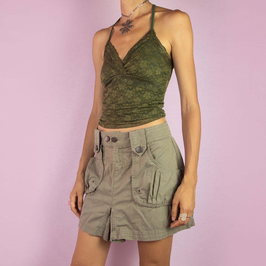 The Y2K Cargo Khaki Mini Skirt is a vintage 2000s piece featuring a mid-rise fit and a mini length silhouette. Made from green cotton, the skirt is designed with cargo-style front pockets and decorative button details. It includes a front button and zipper closure, making it perfect for casual wear and outdoor adventures.