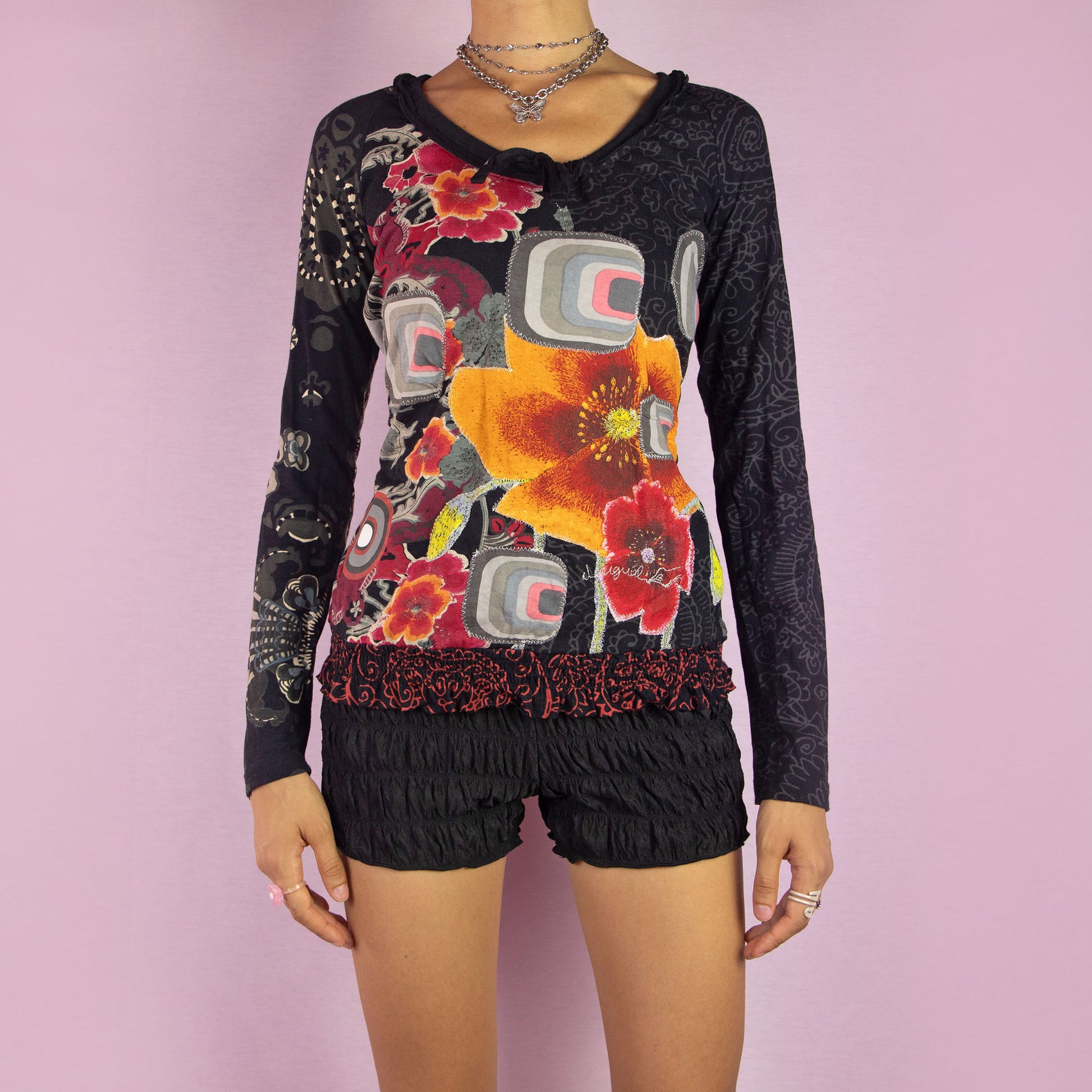 The Y2K Desigual Print Top is a vintage shirt from the 2000s, featuring a vibrant and eclectic design that combines large floral patterns with geometric shapes and abstract motifs. This long-sleeve top showcases a unique blend of contrasting prints, characteristic of the Desigual brand. Its playful and artistic aesthetic makes it perfect for creating a bold, statement look.