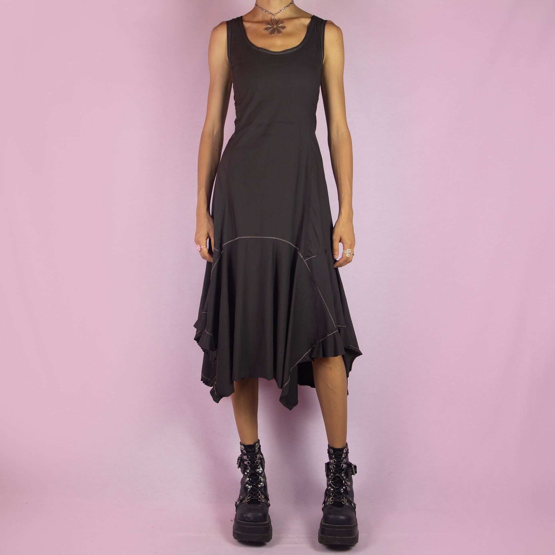 The Y2K Asymmetric Brown Midi Dress is a vintage 2000s sleeveless piece with a stretchy fabric and a pointed, asymmetric hemline. Its flowy silhouette and minimalist design make it perfect for casual wear and evening events.