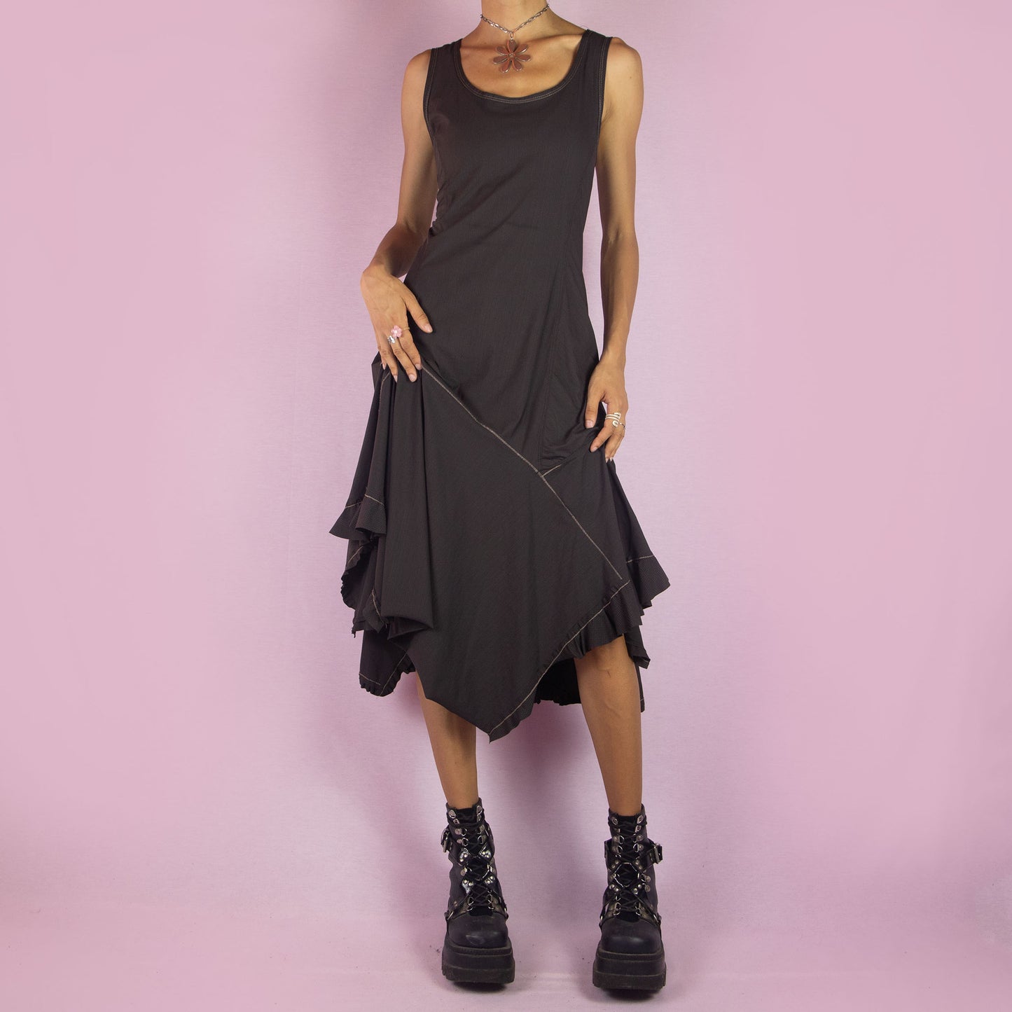 The Y2K Asymmetric Brown Midi Dress is a vintage 2000s sleeveless piece with a stretchy fabric and a pointed, asymmetric hemline. Its flowy silhouette and minimalist design make it perfect for casual wear and evening events.