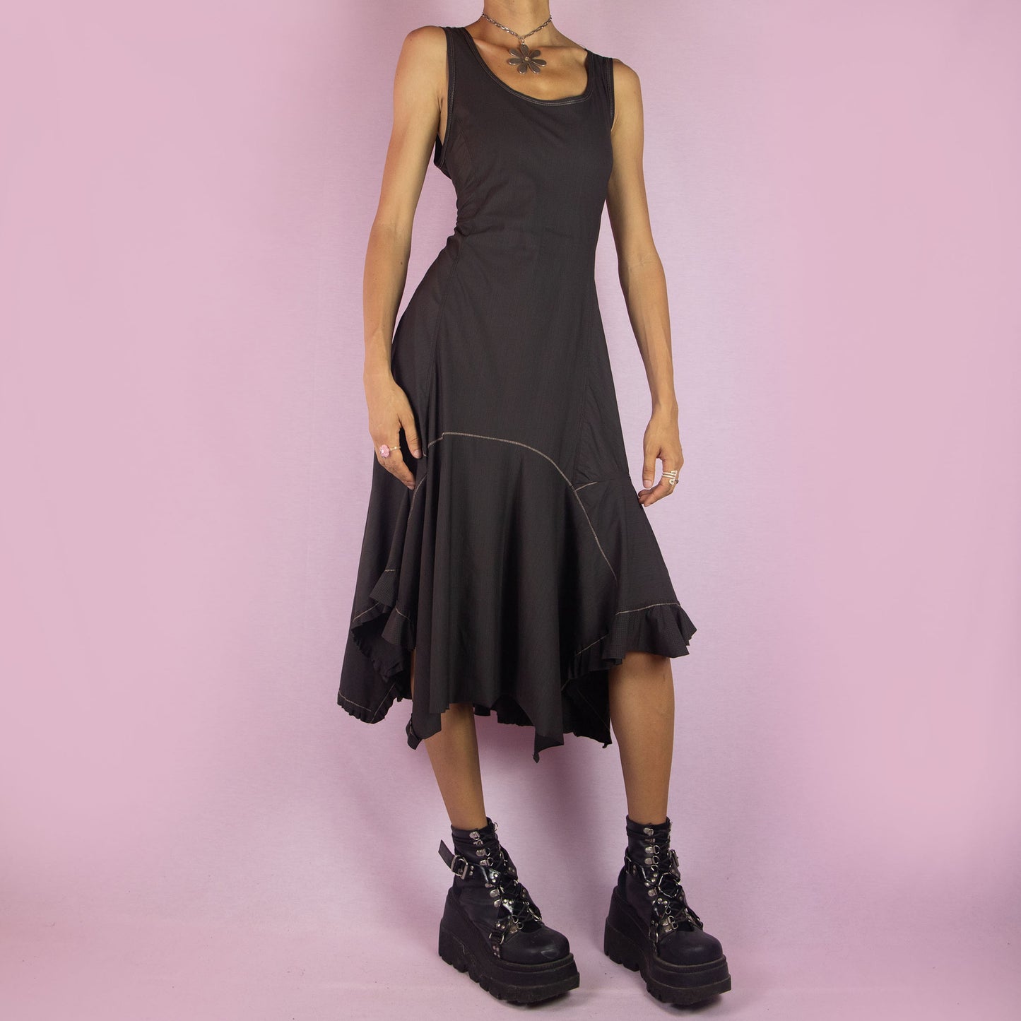 The Y2K Asymmetric Brown Midi Dress is a vintage 2000s sleeveless piece with a stretchy fabric and a pointed, asymmetric hemline. Its flowy silhouette and minimalist design make it perfect for casual wear and evening events.